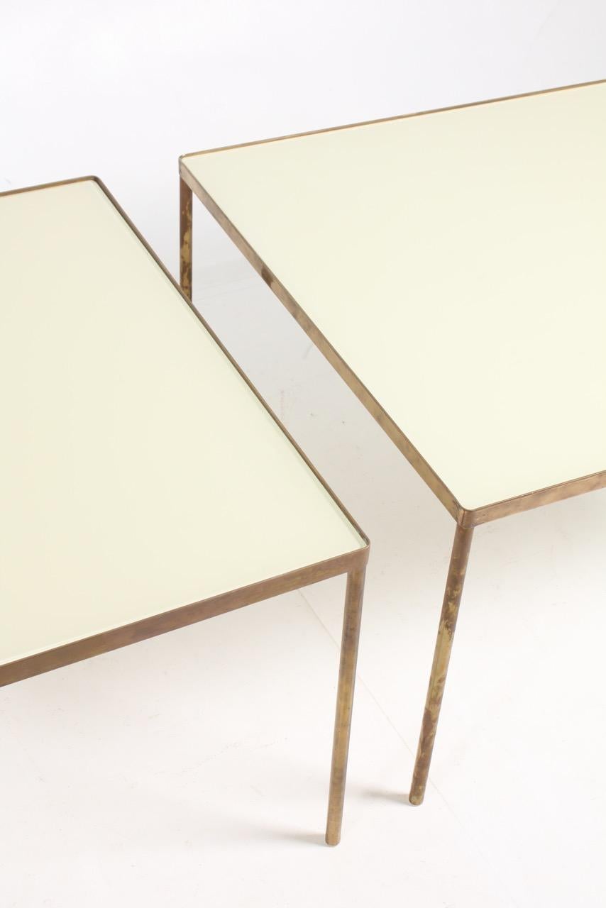 A pair of side tables with glass top on a brass frame. Sold by Illums Bolighus in 1960s, Denmark. Great original condition.