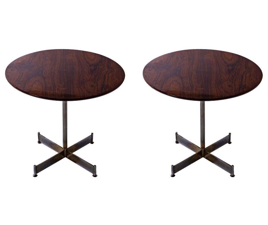 Une paire frappante qui distille le langage de conception de Rodrigues dans sa forme la plus essentielle. Les plateaux circulaires, réalisés en palissandre jacarandá richement figuré, reposent sur des bases métalliques cruciformes sculpturales - une