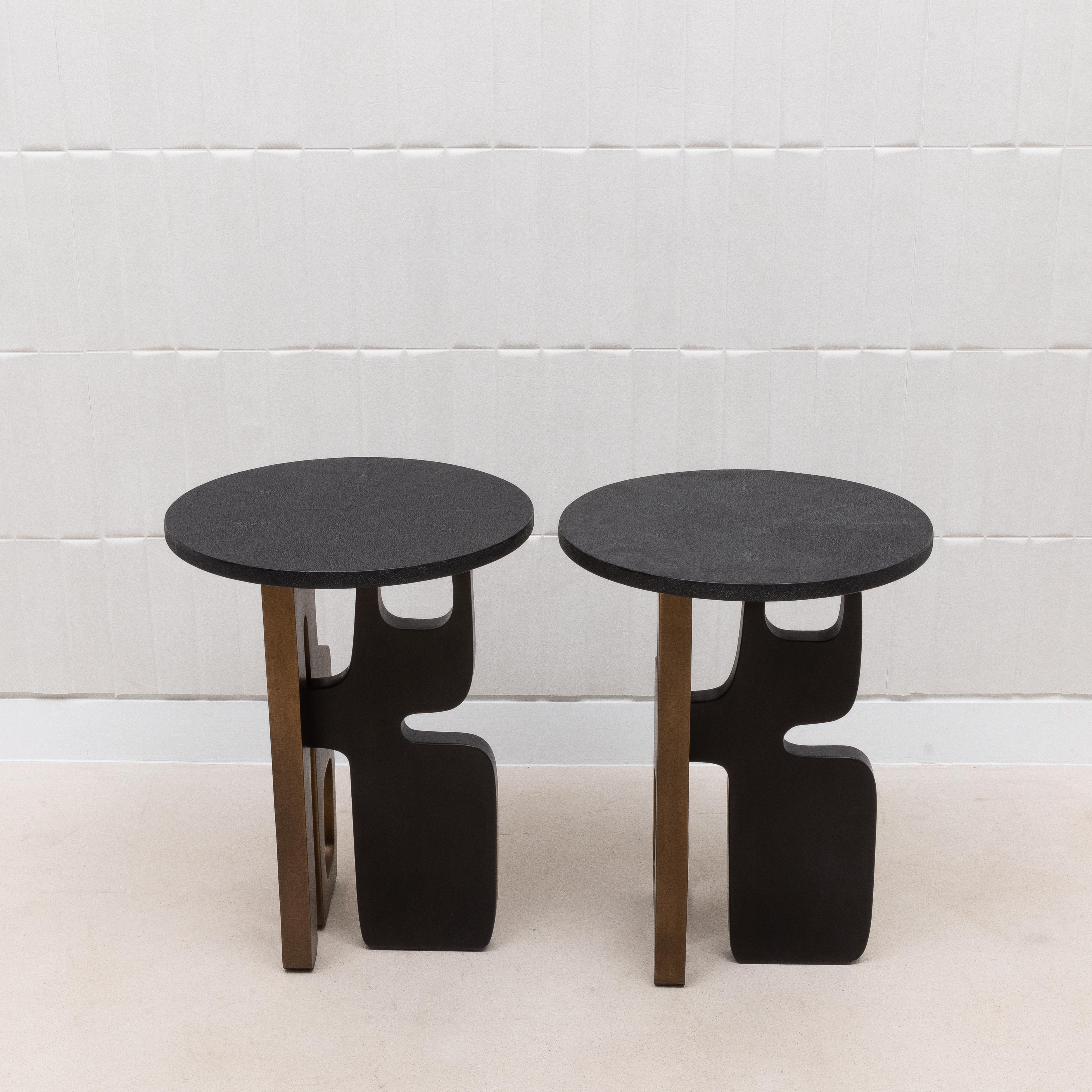 Das Beistelltischpaar Apoli von Kifu Paris besticht durch seine Kombination aus kühnem modernen Design und luxuriösen Materialien. Die aus tiefschwarzem Chagrin gefertigte Platte bietet eine glatte, raffinierte Oberfläche, die einen schönen Kontrast