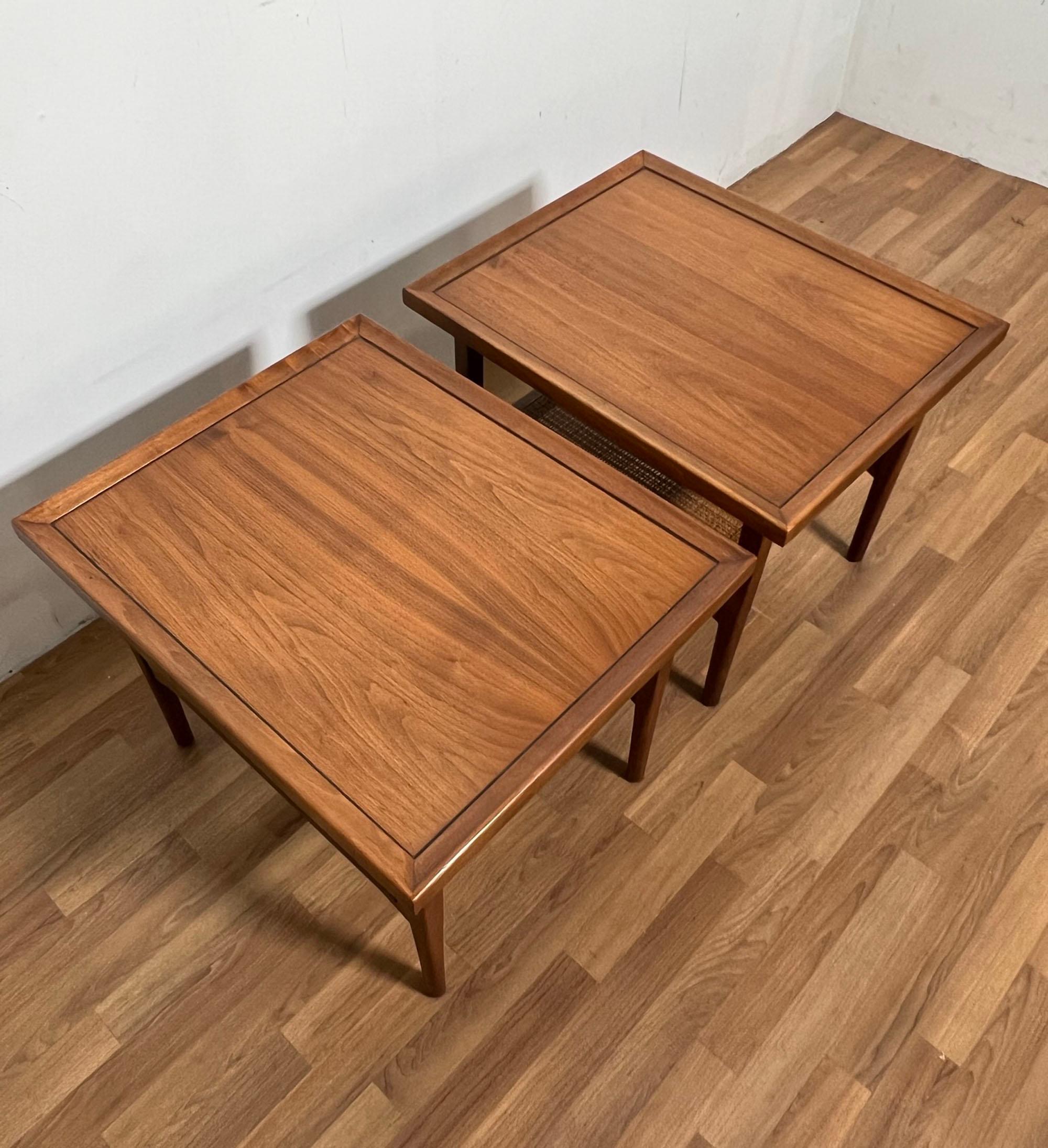 Pair of end tables in walnut with cane undershelves by Kipp Stewart for Drexel, circa 1960s.