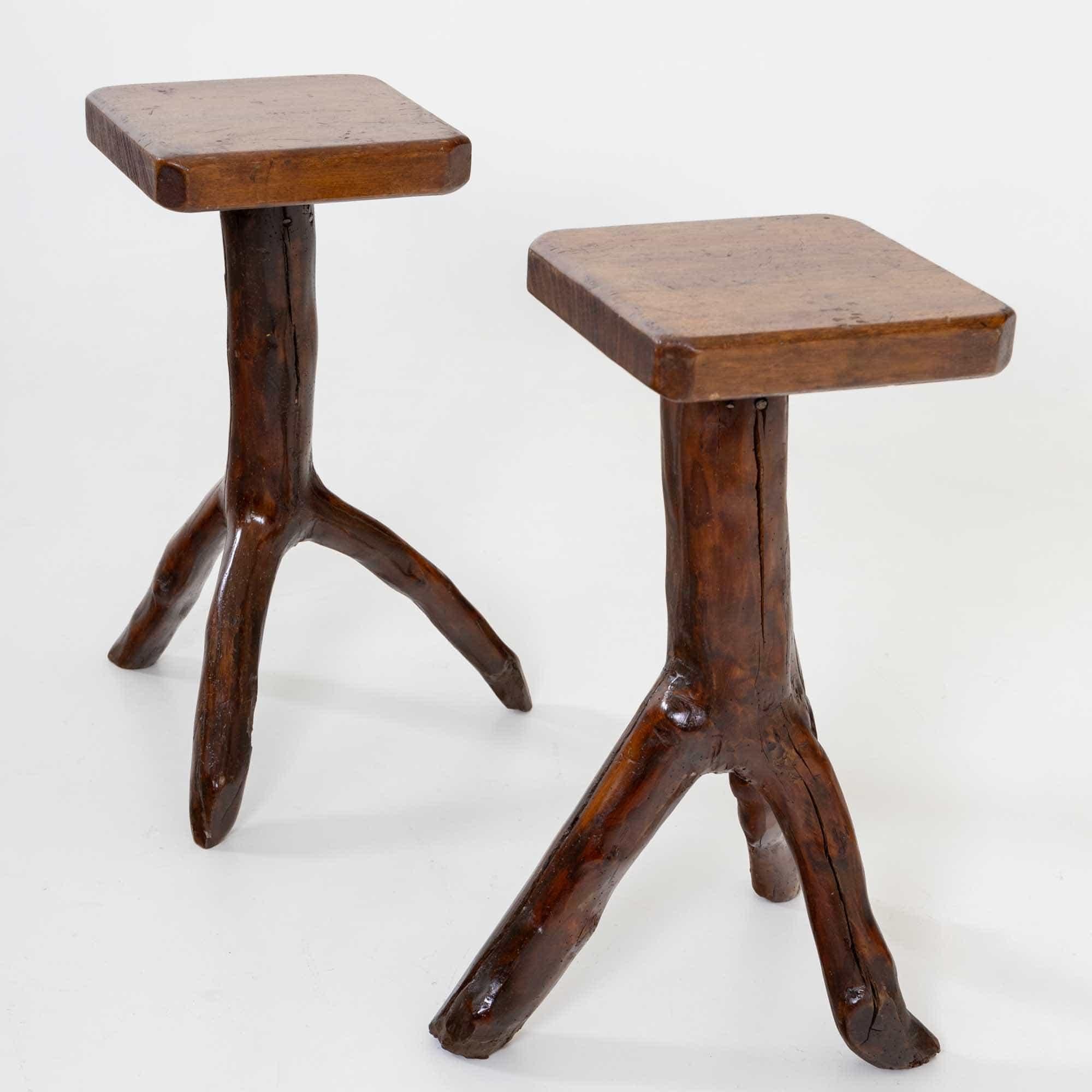 Pair of side tables with tabletops measuring 32 x 30 cm. The three-legged bases of the tables are made from natural tree branches and have been polished and waxed smooth.