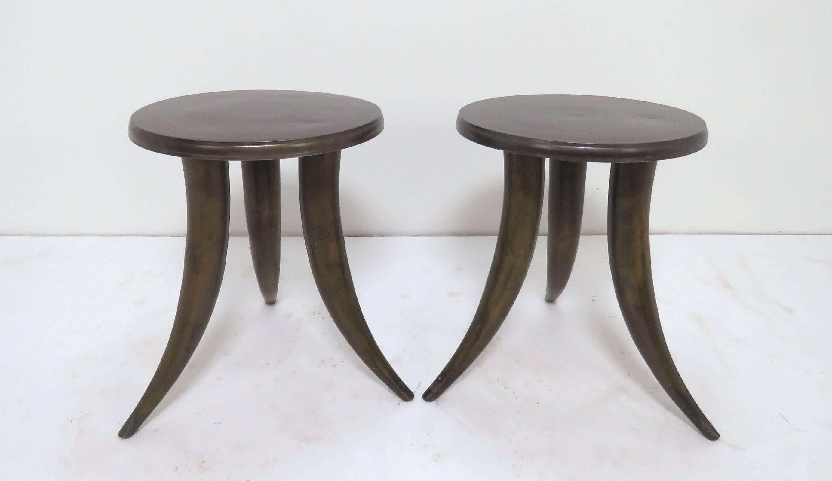 Pair of side tables in metal with a bronzed finish and tusk-form legs, circa 1960s. Sturdy enough to serve as stools as well.