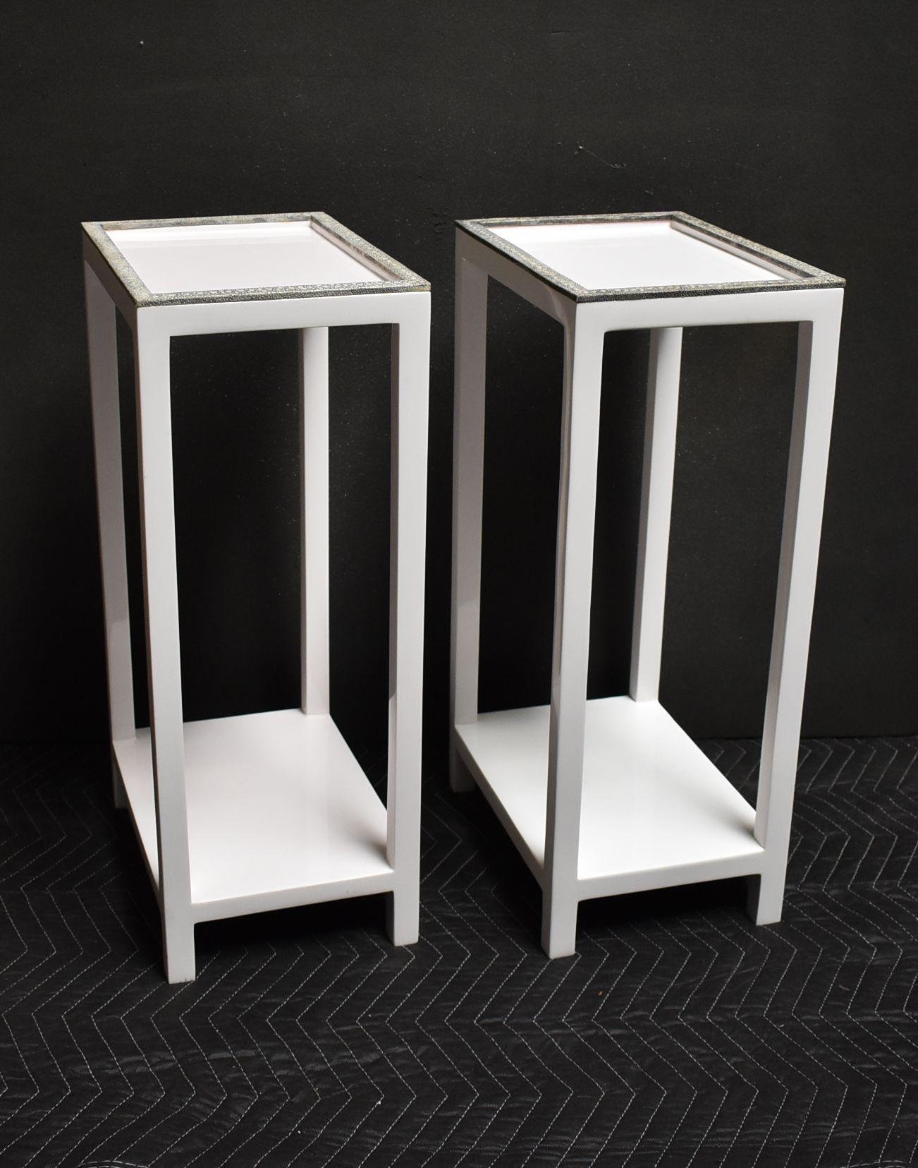 Paire de tables d'appoint à deux niveaux en résine blanche avec bordure en galuchat gris et blanc.