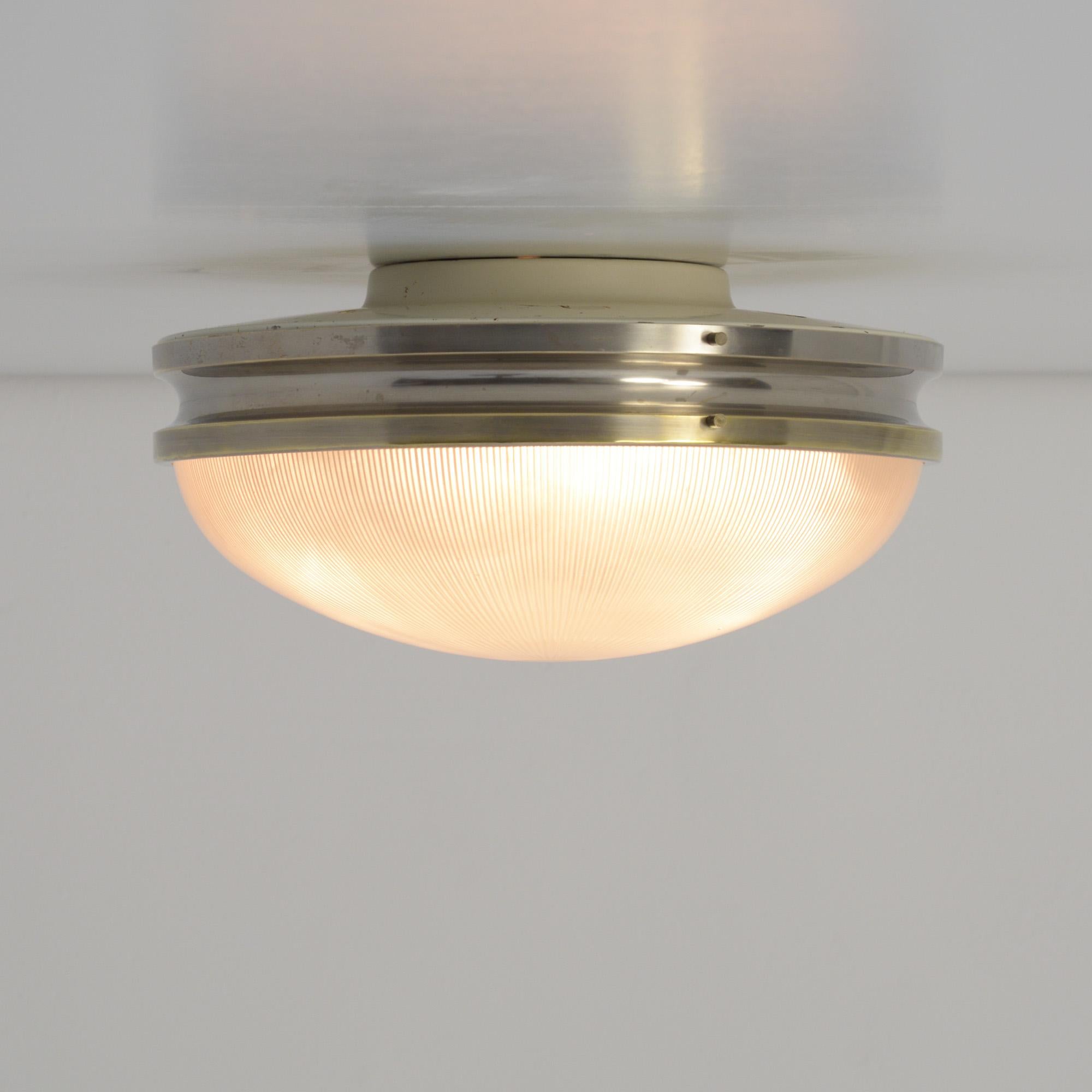 The sigma ceiling lamp was created by Sergio Mazza for Artemide in the 1960s.
The lamp is made of nickeled brass and pressed glass.
We offer you a pair. The lamps were created as ceiling lamps but can also be used as wall lamps.
Both lamps are in