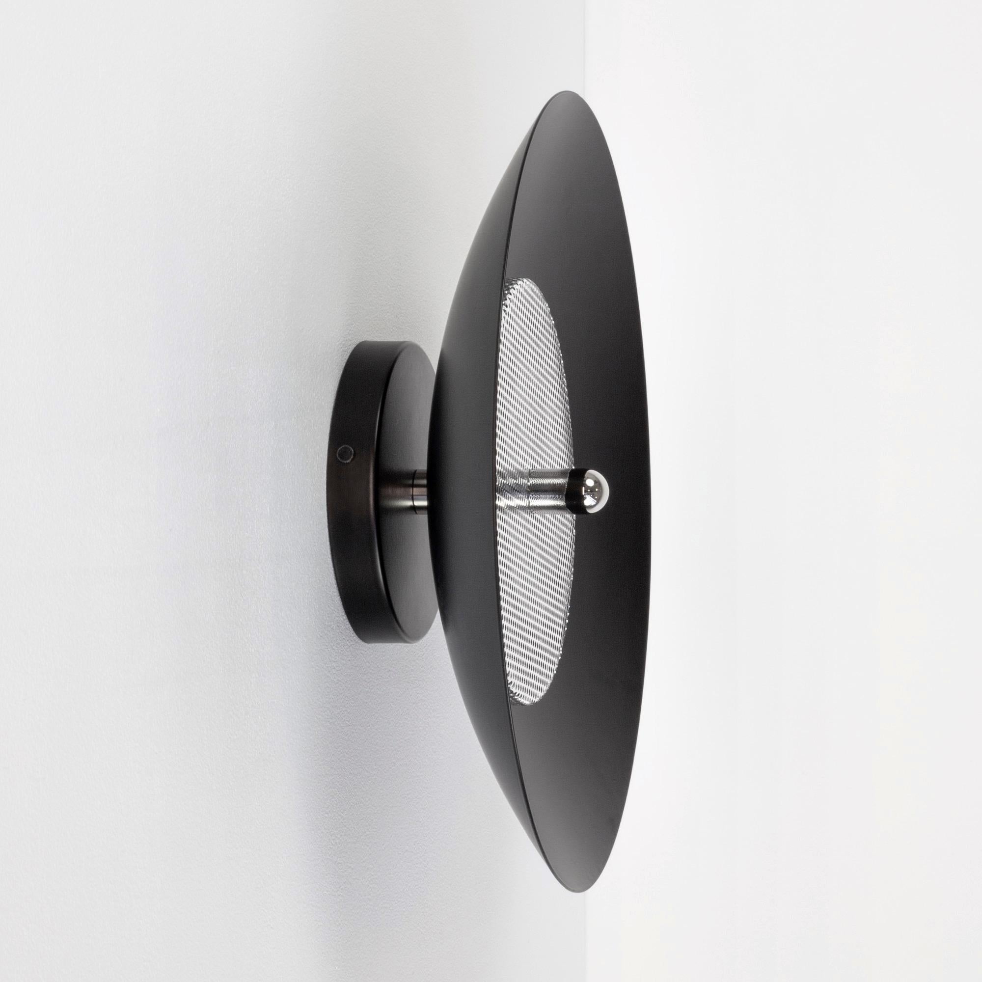 This listing is for 2 signal sconces from Souda.
Composed of a spun metal shade that reflects light filtered through a perforated metal diffuser, the subtle warmth of the Signal sconce is perfectly balanced by it’s striking form. With their refined