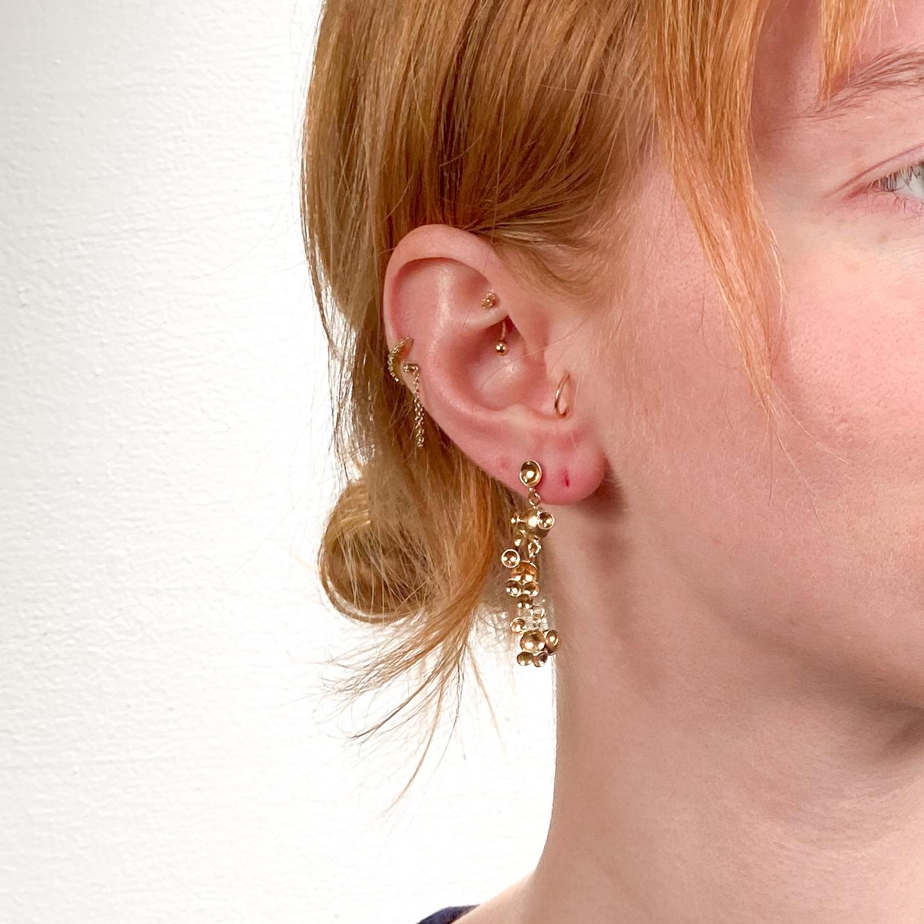 Un bel paio di orecchini in oro firmati Modernisti.

In oro 14k.

Composto da maglie di piccoli emisferi o mezze bolle saldate e collegate con piccole catene. La serie di link di ogni orecchino è l'immagine speculare dell'altro.

Ciascuna firmata