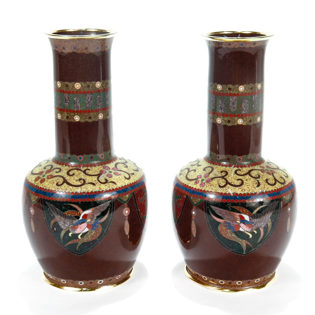 A fine pair of Japanese Meiji period cloisonne enamel vases.

By the Ohta Cloisonne workshop of Aichi Prefecture, Japan. The workshop is better known by its trade name of Daikichi.

Decorated with phoenix and dragon devices on a rich goldstone