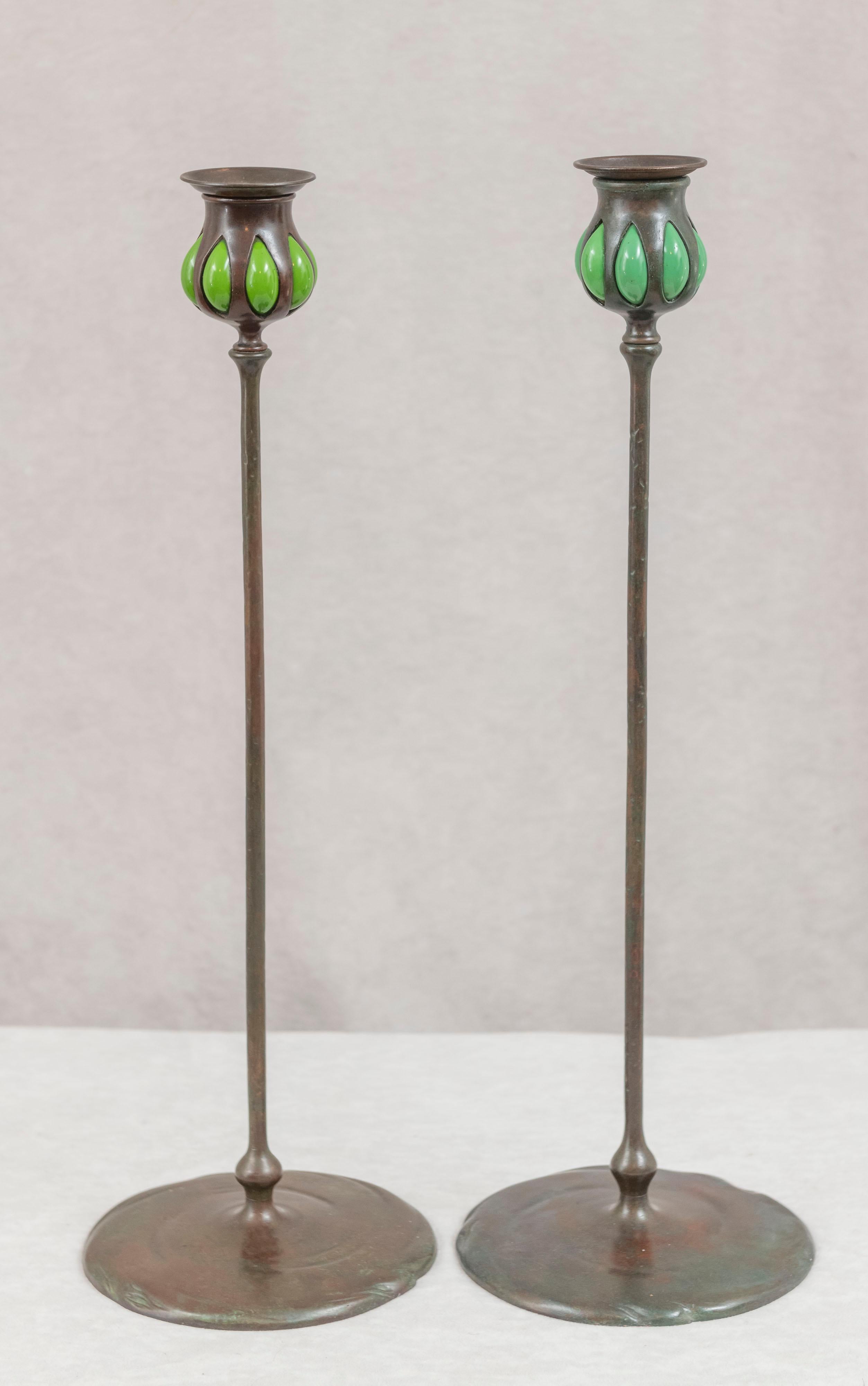 These long and graceful candlesticks were made by and signed by the famous Tiffany Studios. Louis Comfort Tiffany made more than just lamps, for those who are unaware of this fact. He did desk sets, clocks, and much more, and of course, in this case