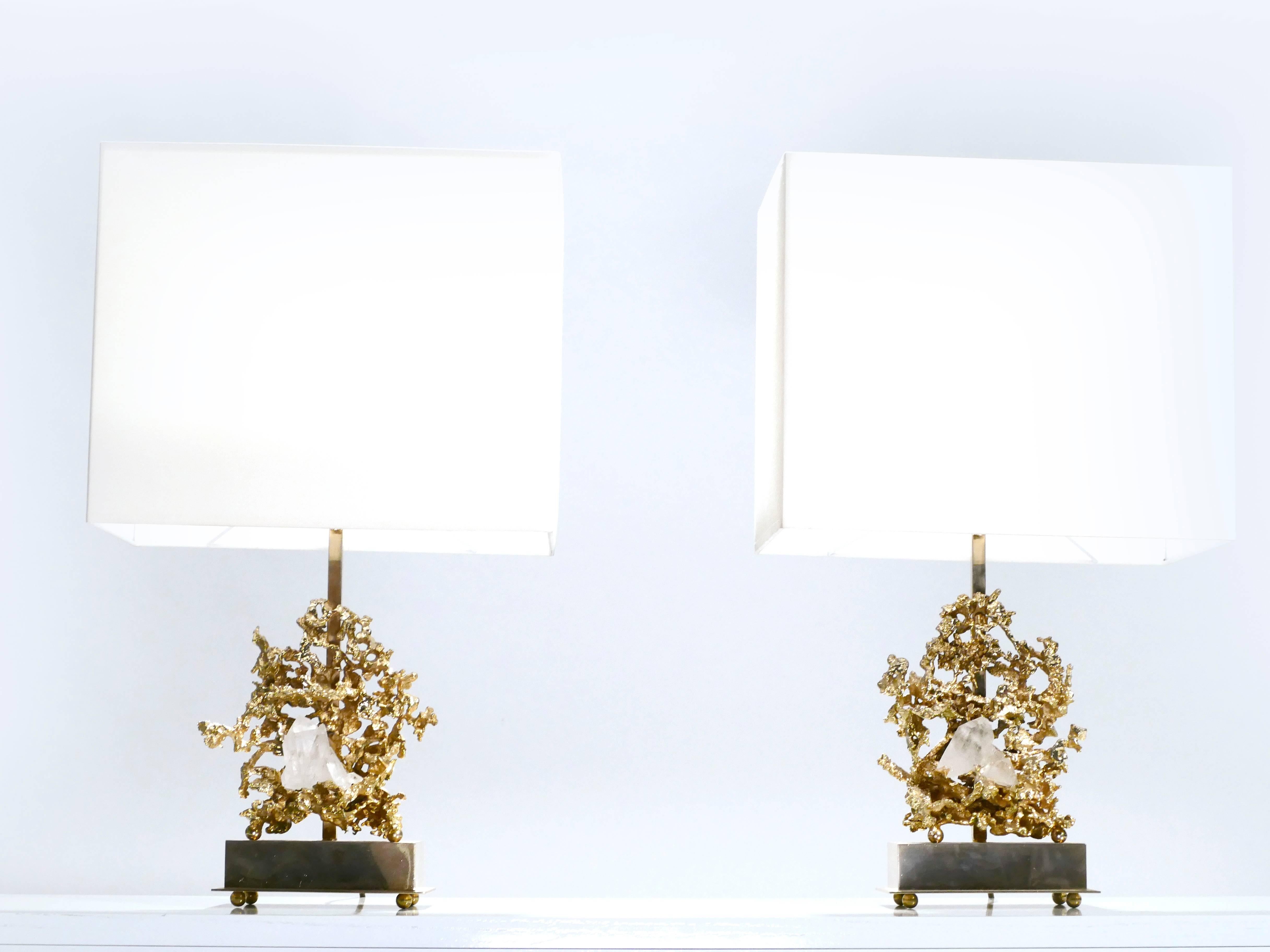 This pair of Claude Victor Boeltz table lamps has the intricacy of fine jewelry. Bronze is sculpted to look miraculously molten and gravity-dying, forming part of the base. Among the twisty bronze nestles a translucent crystal rock inclusion. The