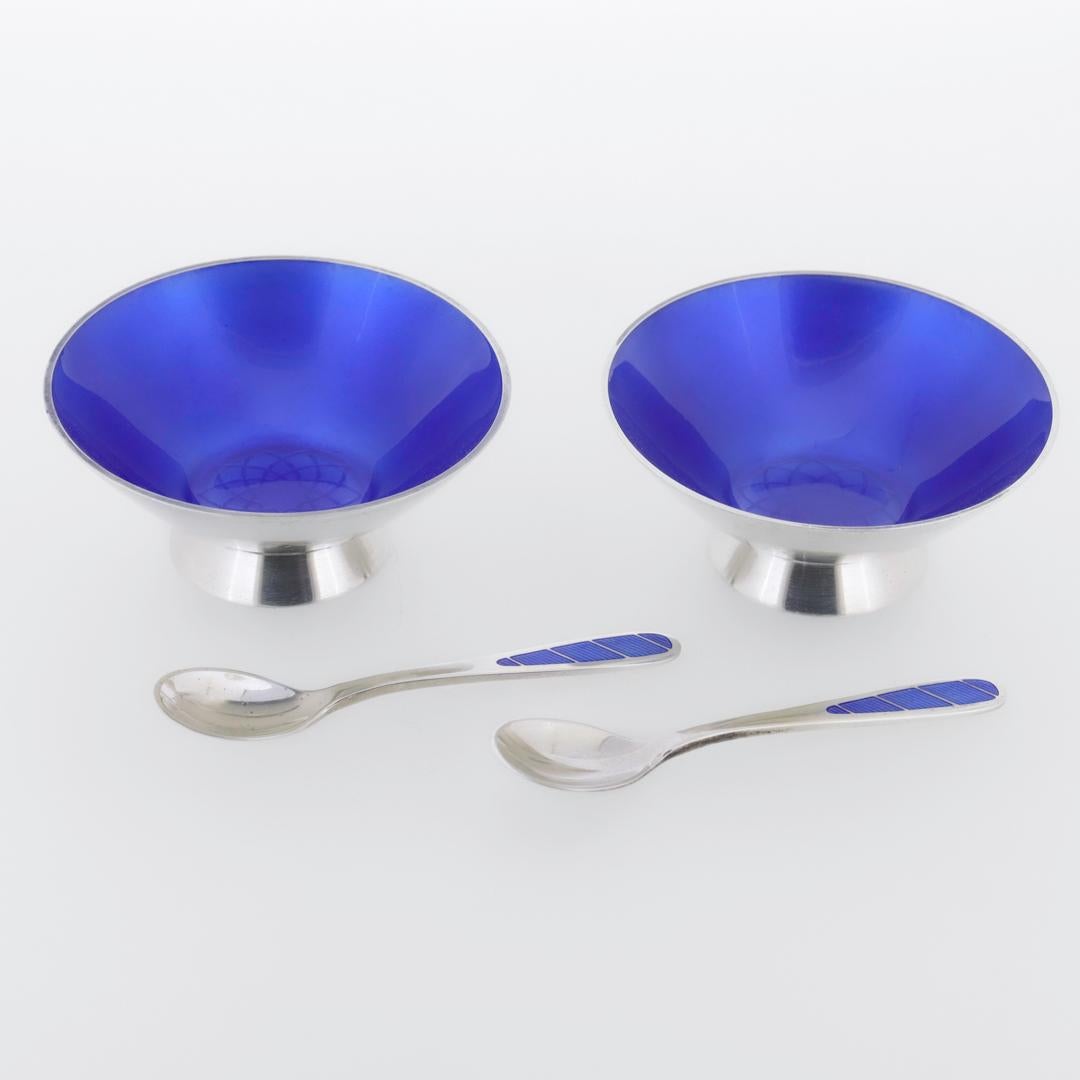 A fine pair of vintage Danish Modern silver & enamel salt cellars & spoons.

In sterling silver.

By Egon Lauridsen (active ca. 1936 - 1966)

The cellars with blue enamel to the bowls and starbursts to the center. The spoons with blue enamel