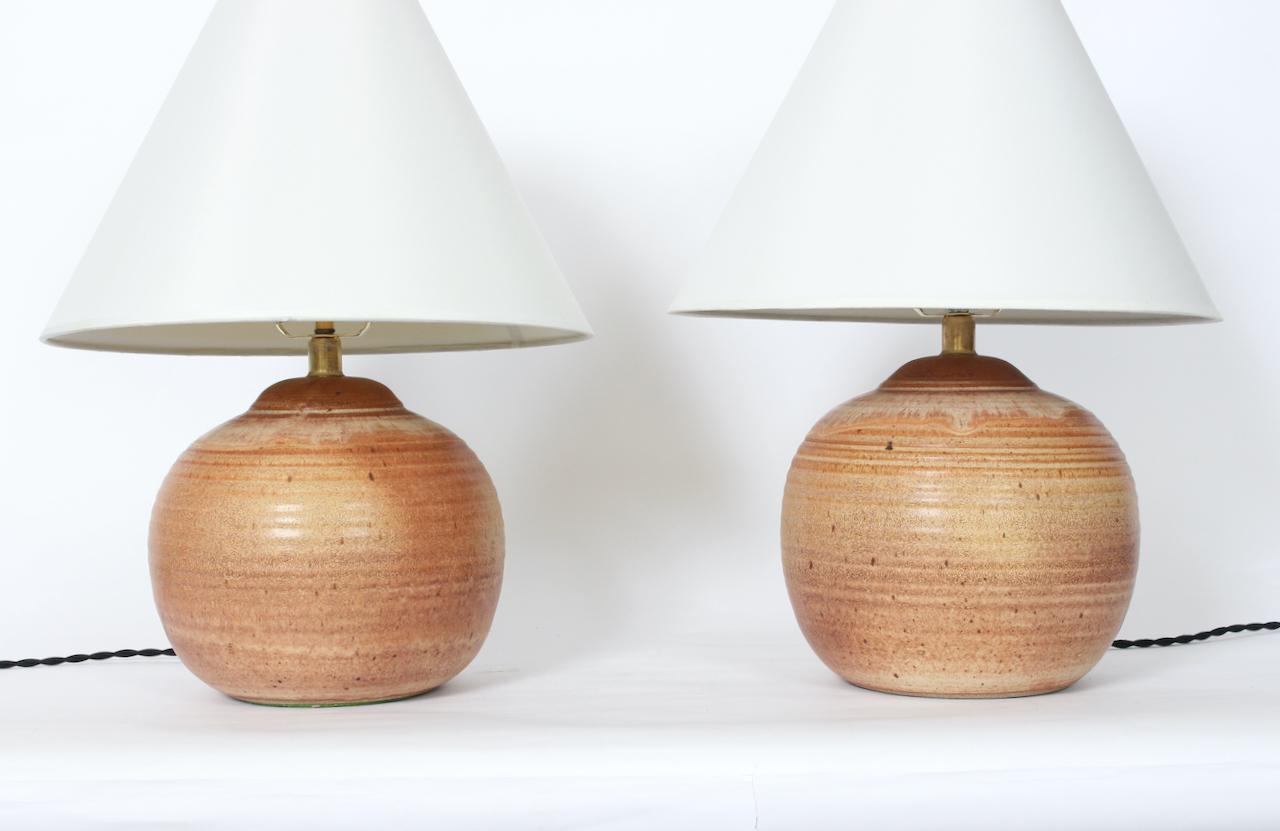 Organic Modern Glazed Natural Art Pottery Orb Bedside Table Lamps, 1988. Featuring smooth ribbed hand thrown Studio Ceramic globe forms in neutral earthenware tones: Beige, Rust, Clay, Tan, Cream and Sandstone. Lamp shades shown for display only and
