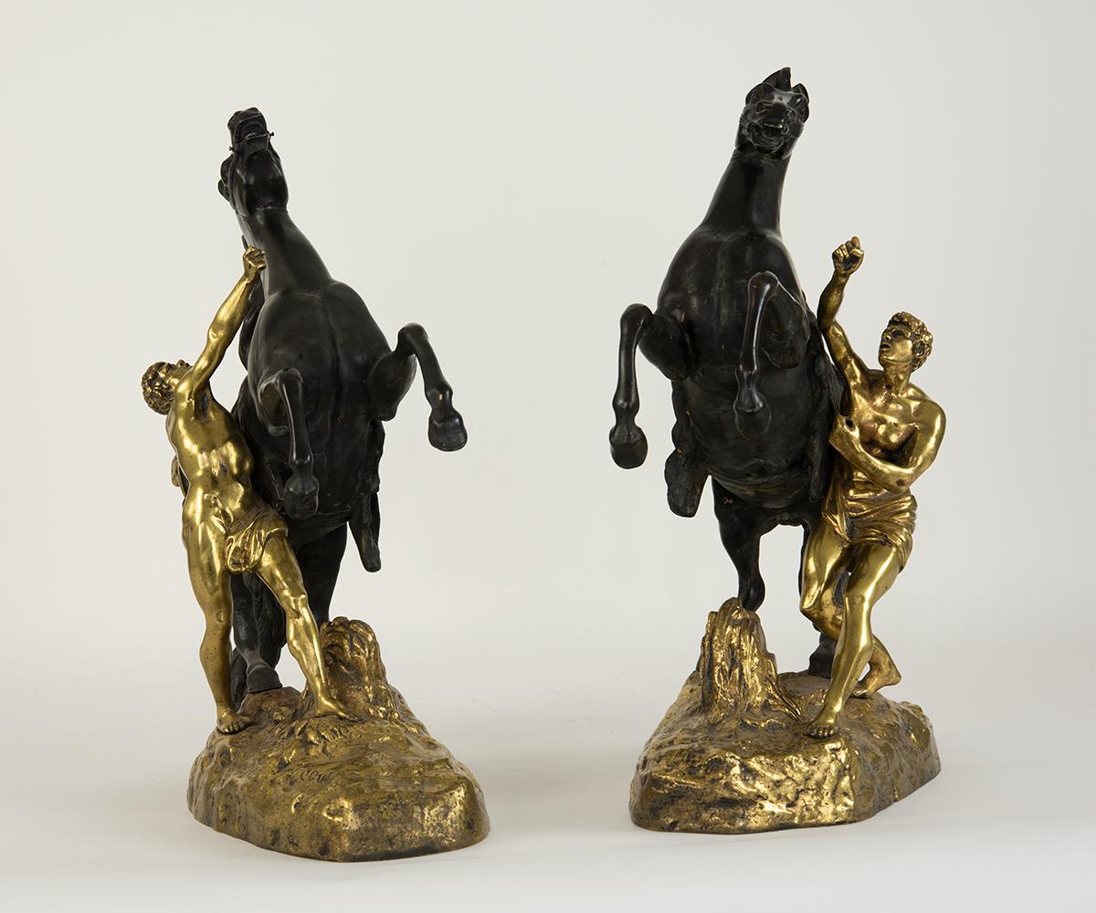This is a pair of French Marley horses with the grooms and the base, which simulates an earthen ground, all decorated in a fantastic gilding. Rarely does this famous subject come in two tones and especially not partially gilt as this pair boasts.
