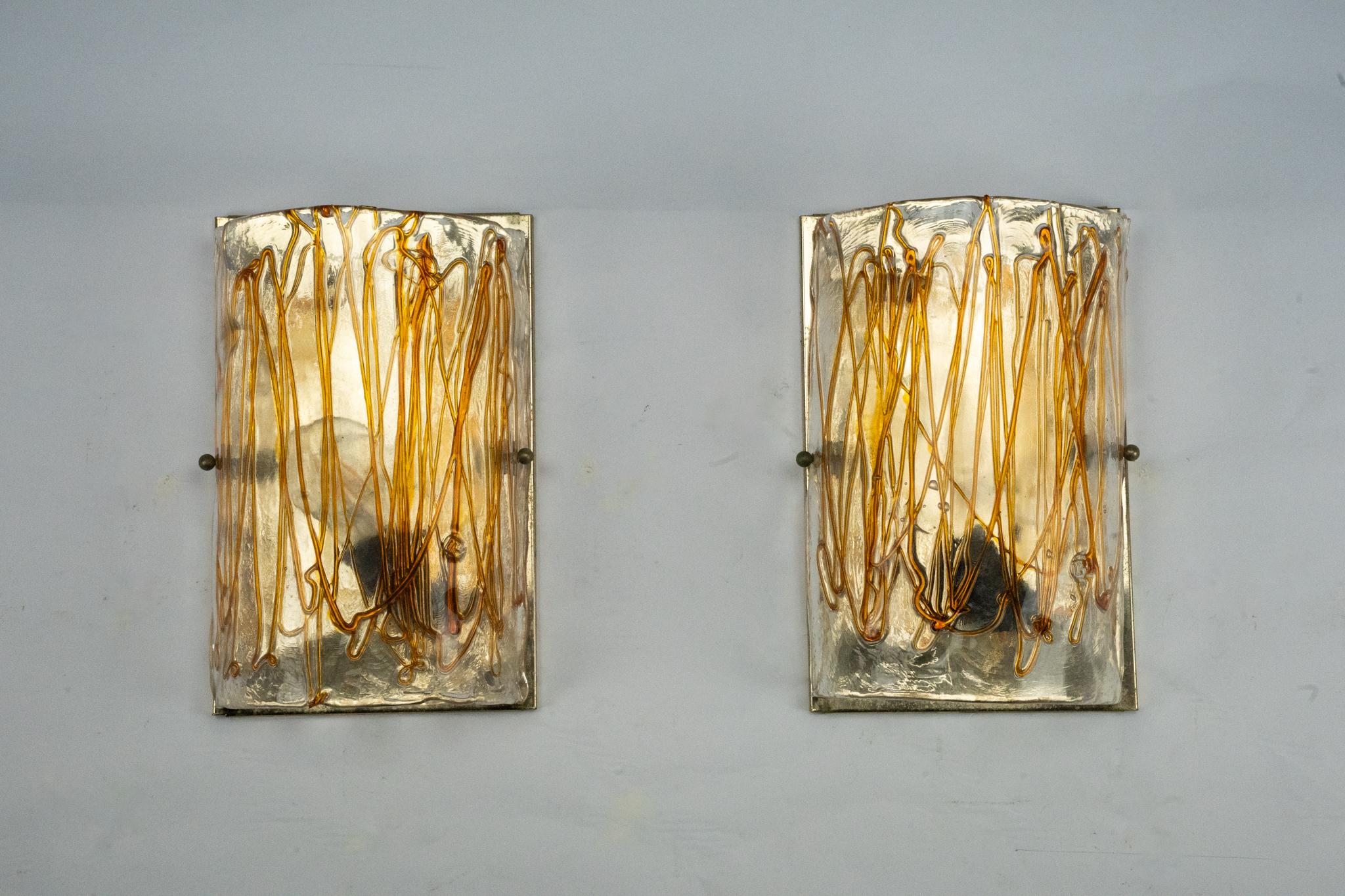 Pareja de apliques de cristal de Murano grueso firmados La Murrina, Italia, años 70. Vidrio transparente escultural con vibrantes inclusiones ámbar, soplado a mano con expresivos motivos orgánicos. Cada pieza está firmada y presenta la artesanía de