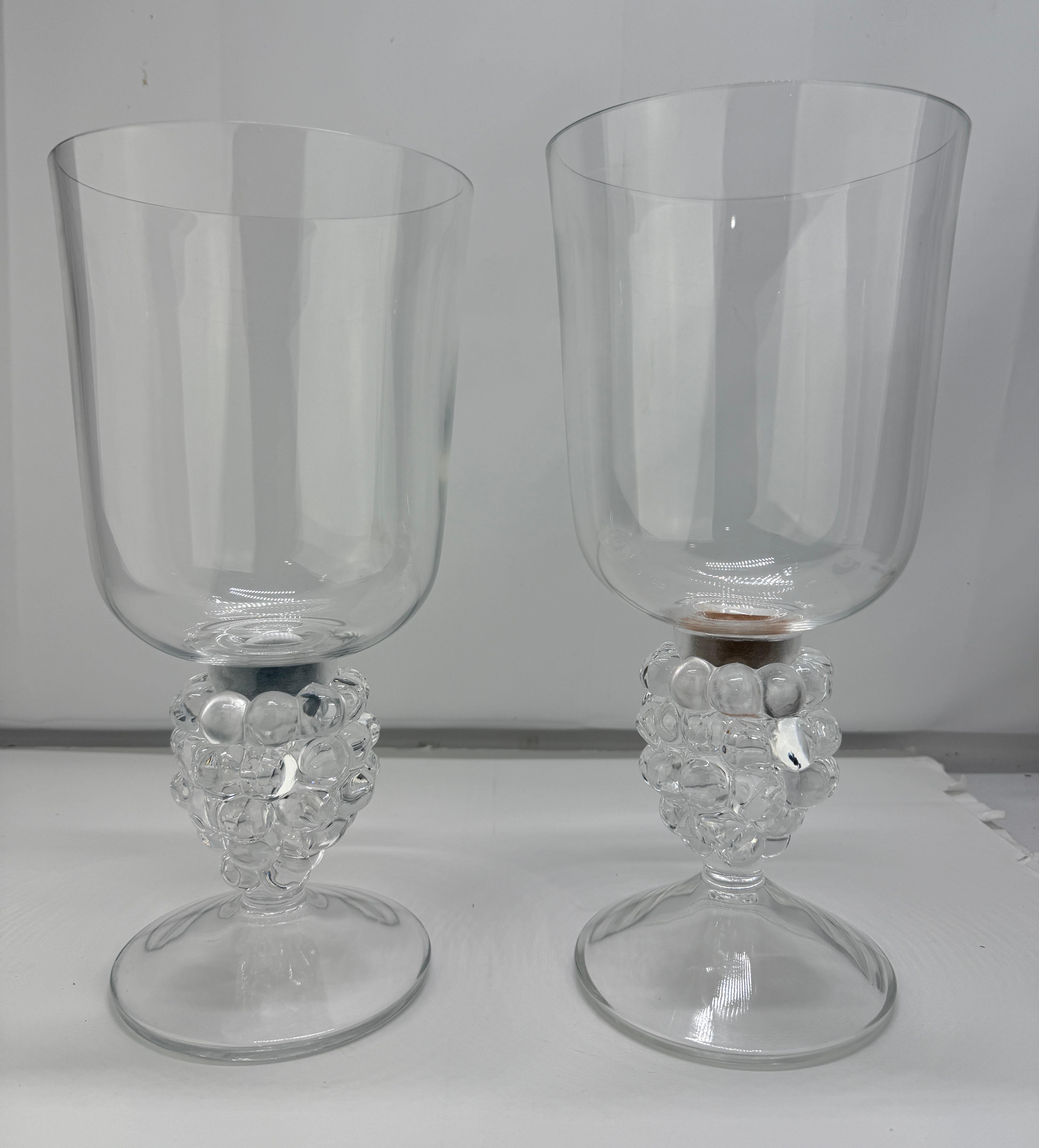 Une paire de bougeoirs en forme d'ouragan en cristal clair du Clos Vougeot Lalique, chacun signé 