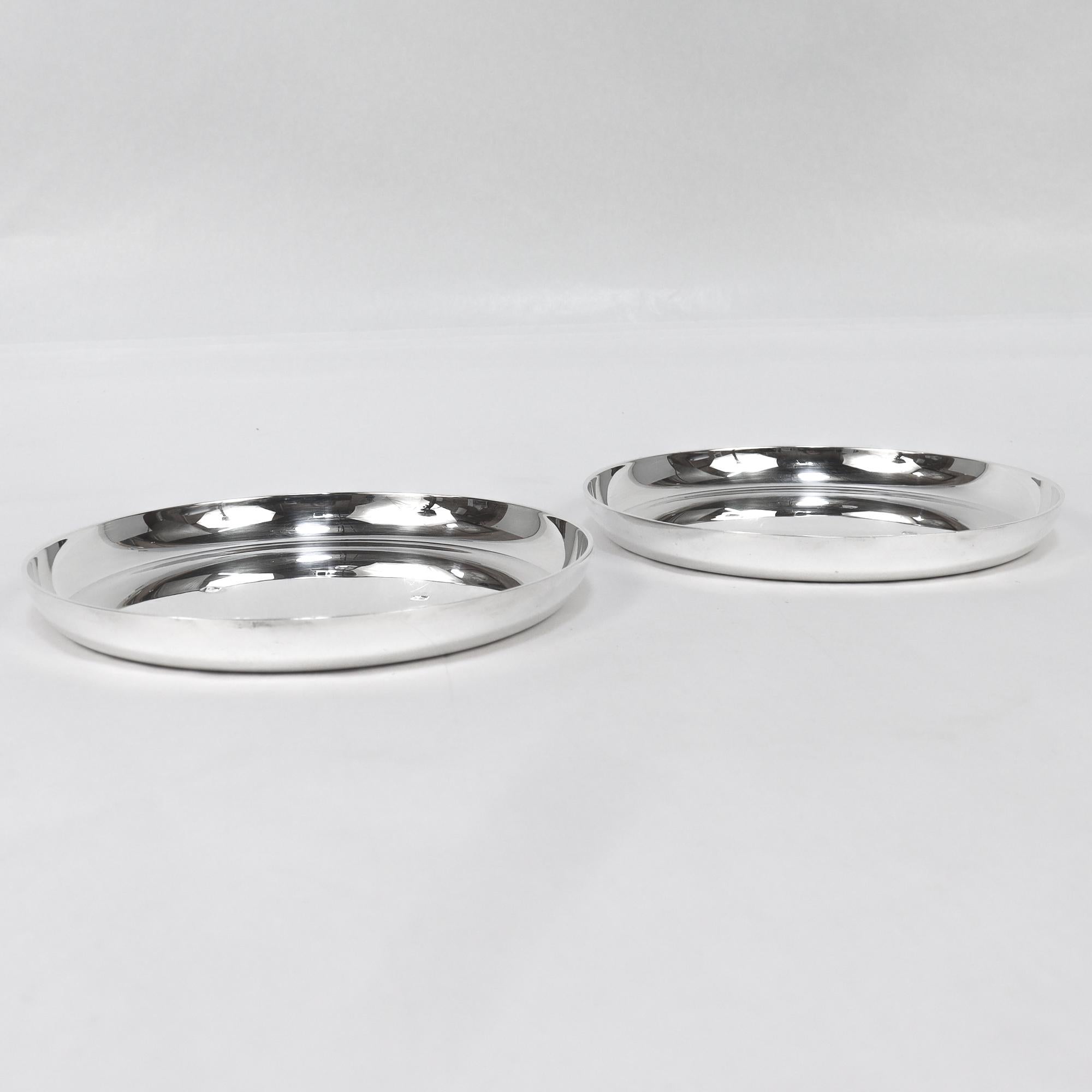 Ein Paar feiner signierter englischer Weinuntersetzer aus Silber aus der Mitte des Jahrhunderts.

Von Asprey & Co.

Aus schwerem Sterlingsilber.

Jede hat einen dicken flachen Boden zur Aufnahme einer Flasche, niedrige gebogene Seitenwände und