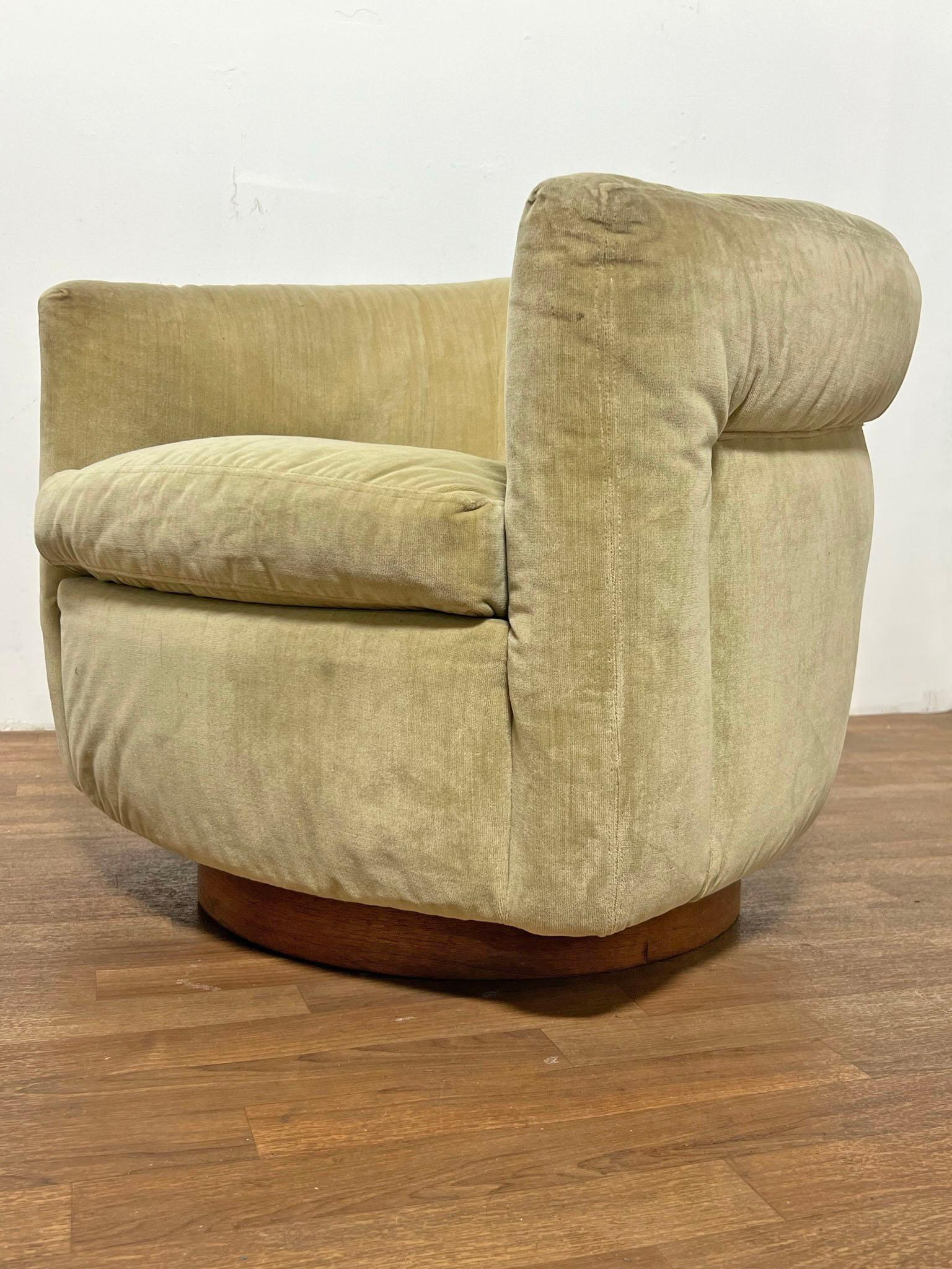 Pair of classic tub lounge chairs designed by Milo Baughman for Thayer Coggin, with walnut bases that swivel and rock. Both retain Thayer Coggin tags, and original order tags from 1972.  Please note a second identical pair from the same estate is