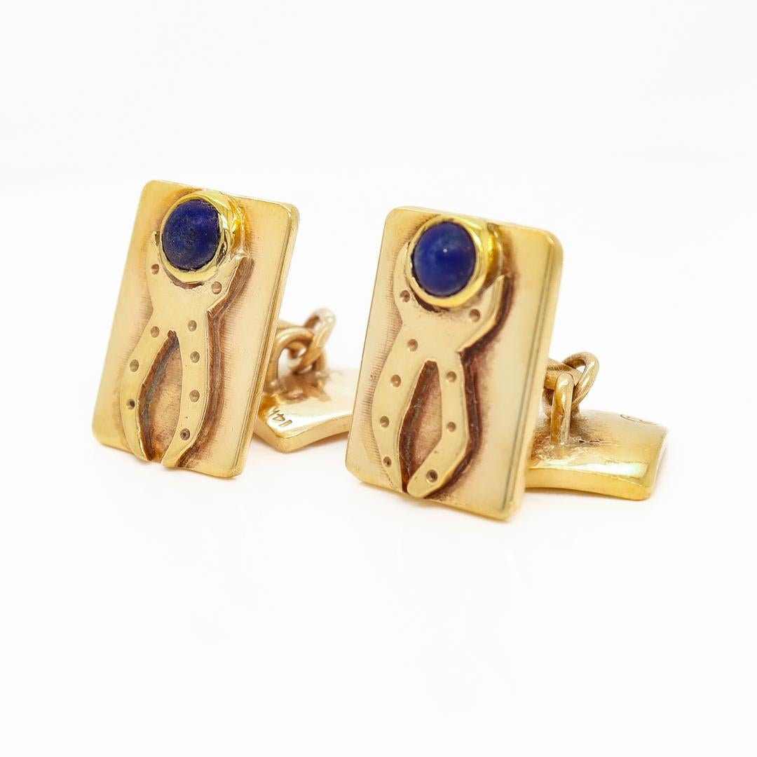 A pair of signed Modernist cufflinks.

By Sam Kramer.

In 14k gold.

Bezel-set with round lapis lazuli cabochons with an applied decoration to the head.

Marked to the reverse with Sam Kramer's mushroom mark.

Simply a wonderful pair of American
