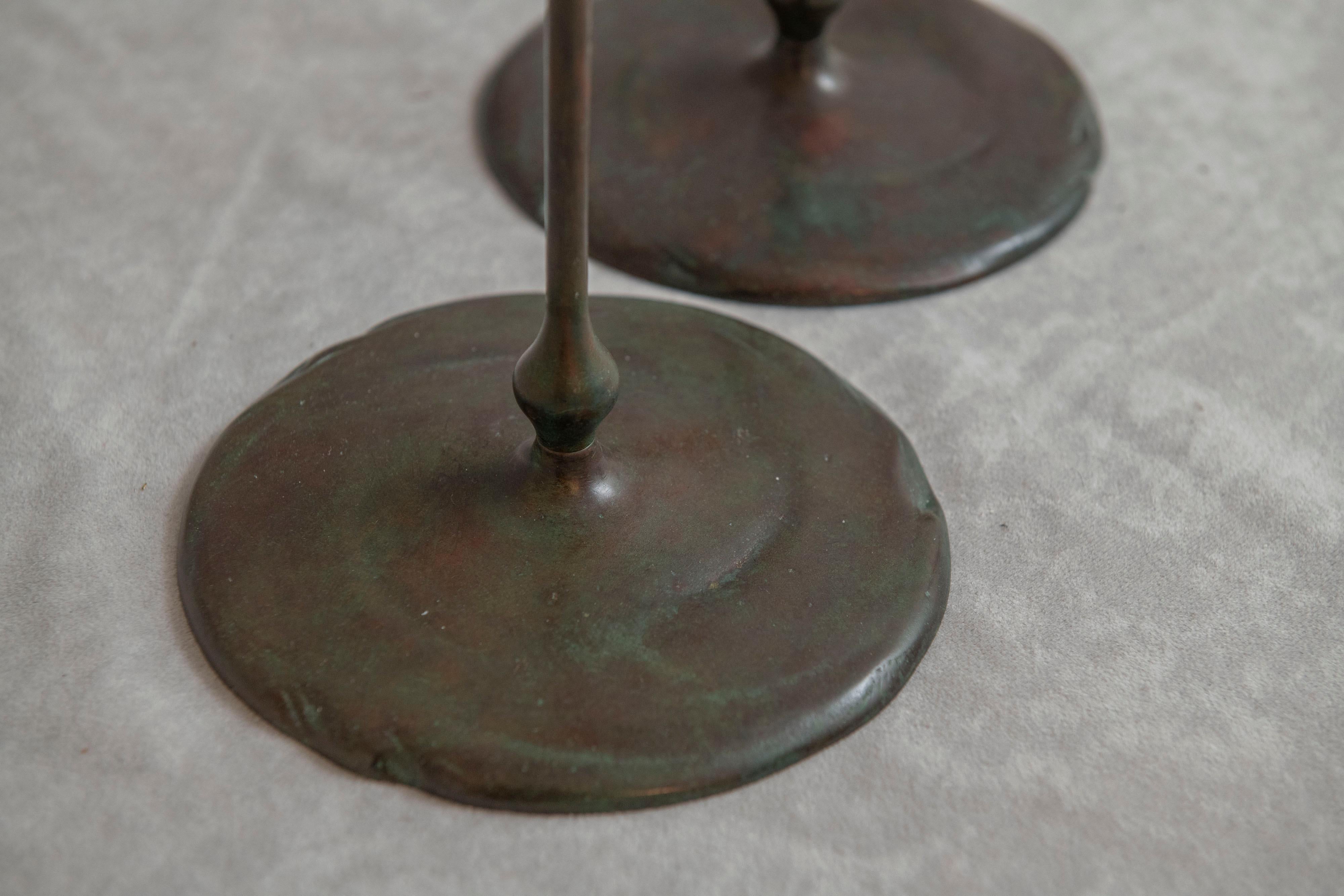 Americano Coppia di candelieri in bronzo firmati Tiffany Studios con portacandele soffiati, 1905 ca. in vendita