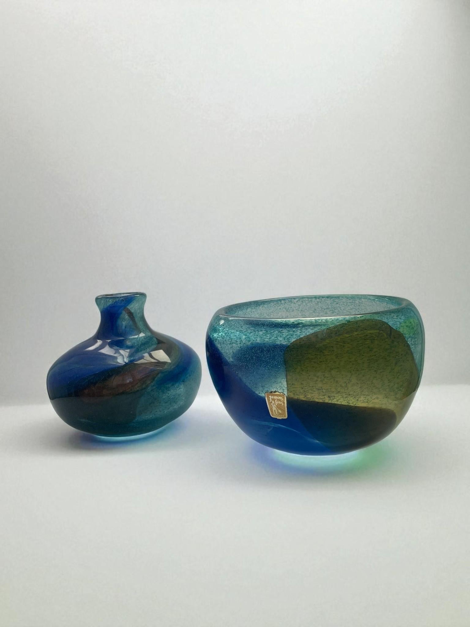 Elegant pair of handblown glass pieces from the “Abstracta” series, designed by Bengt Orup for Johansfors Glasbruk, Sweden, circa 1960s.

The set includes a rounded vase with a narrow neck and a deep bowl form, both showcasing Orup’s masterful sense