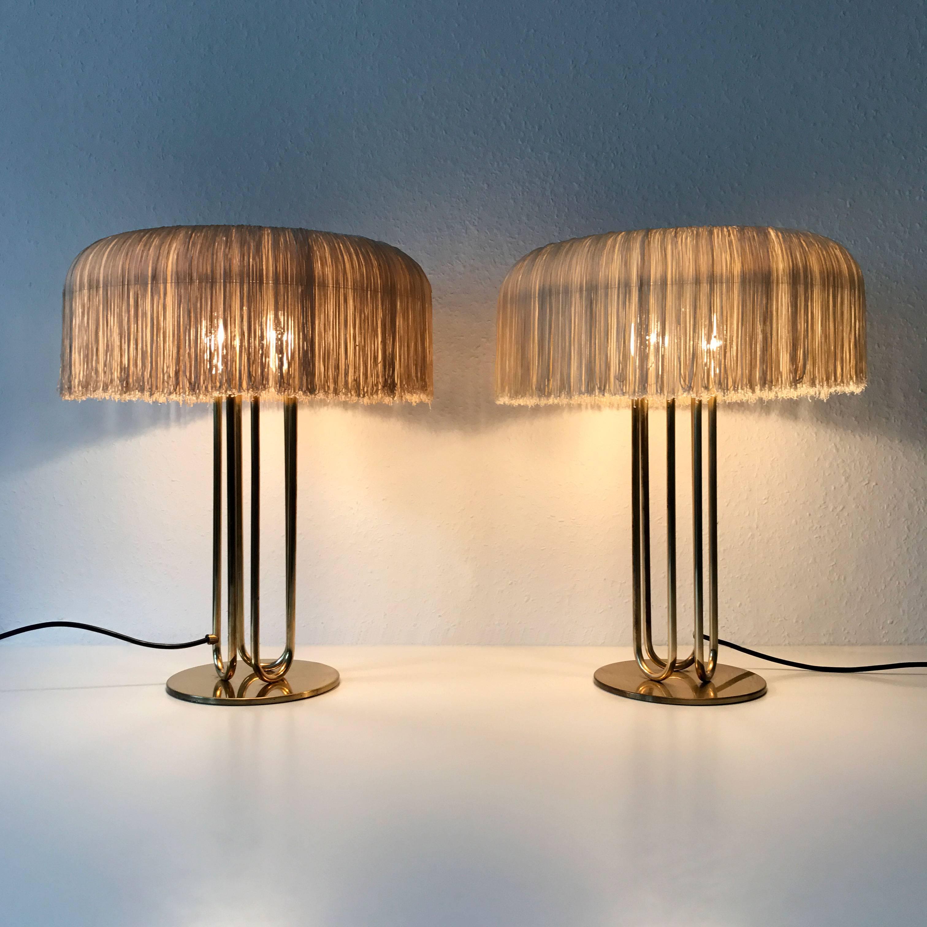 Extremely rare, elegant and large table lamps. Probably designed by Hans-Agne Jakobsson, Markaryd, Sweden, 1950s (Not marked). Executed in brass, anodized aluminium and silk fringes. The silk fringes of the both lamp with slight color difference.