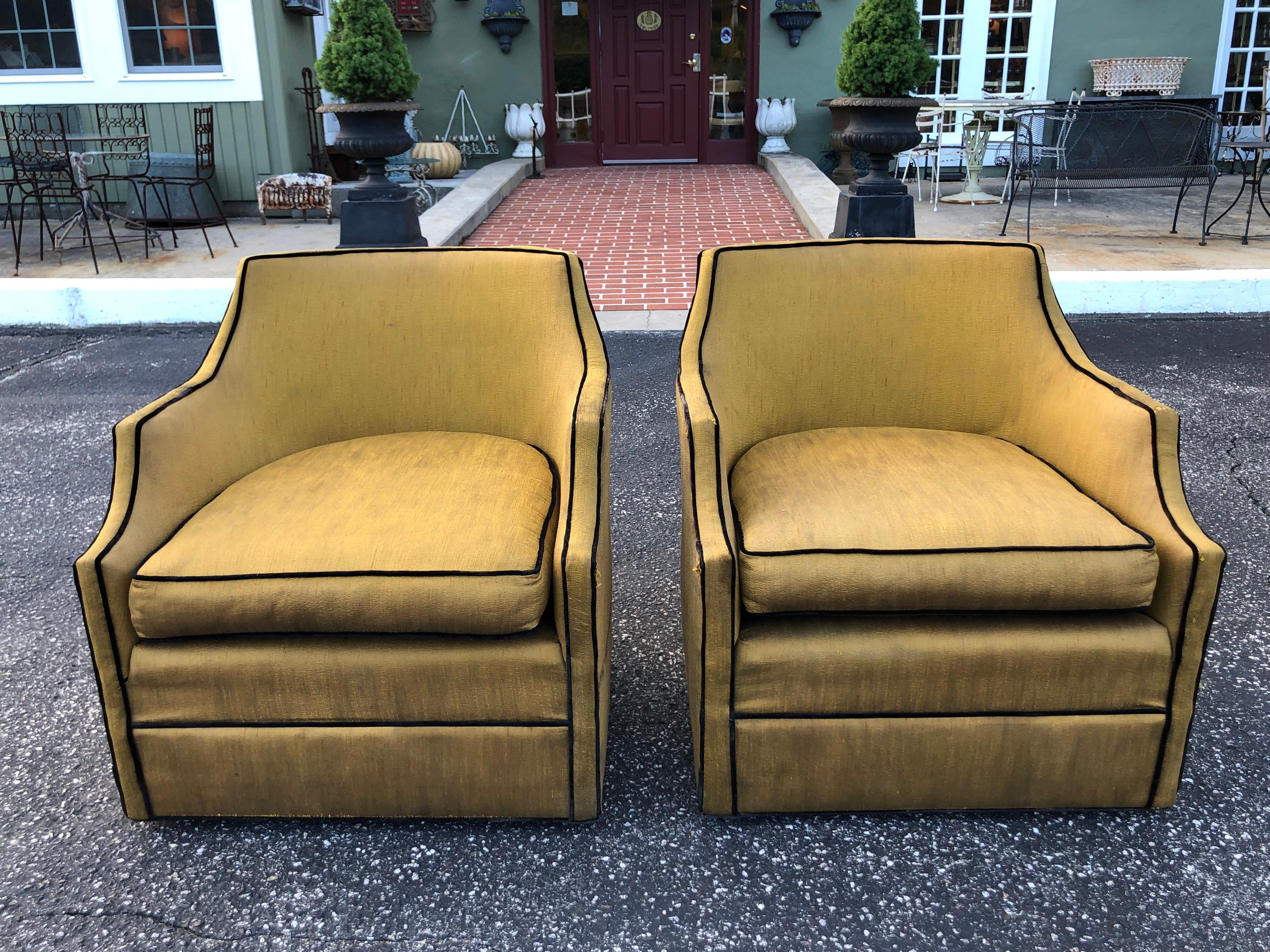 Pair of silk Hollywood Regency swivel chairs. Total Hollywood Glam pair of chairs. Sexy and slender. Fantastic gold silk with black piping. Tufted back pillow that is removable. Fantastic lines and shape. Perfect size as well. Not too big or too