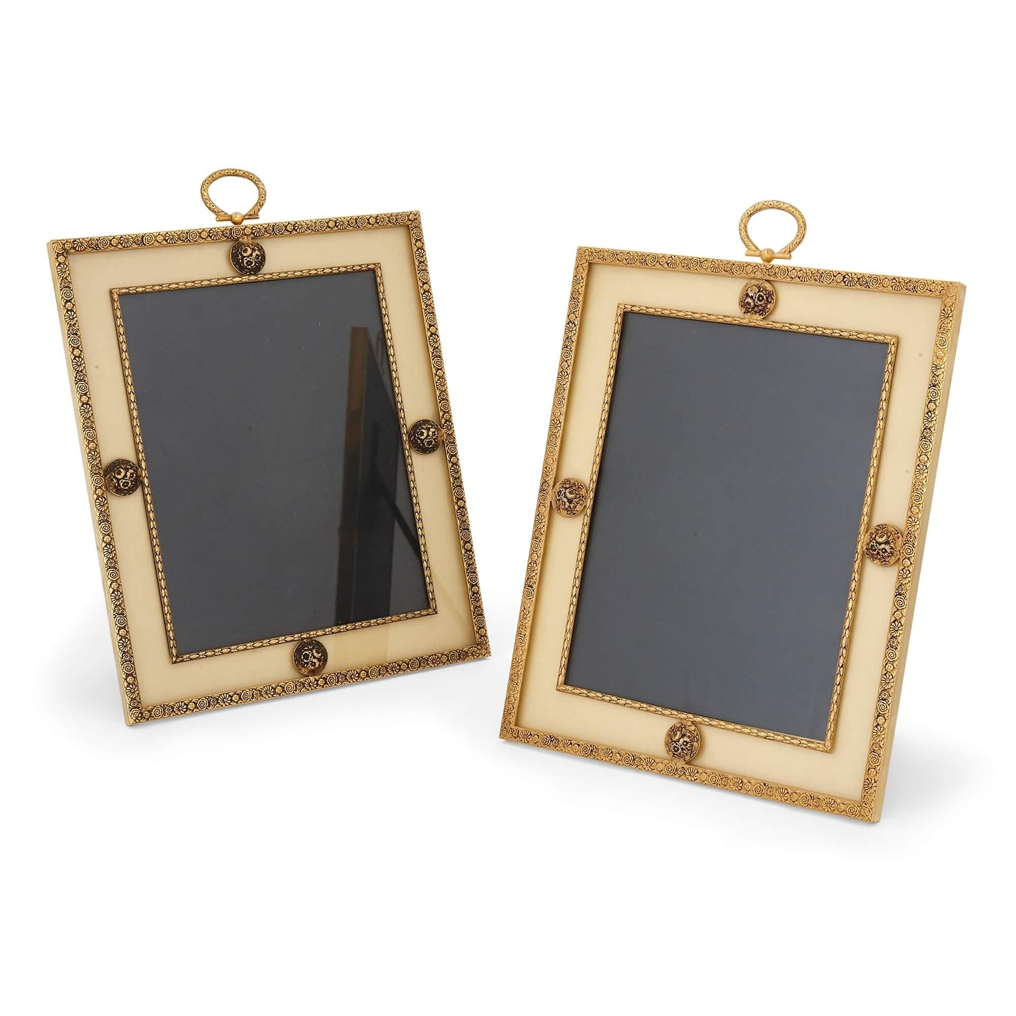Pair of silk mounted gilt metal picture frames by Puiforcat of France
French, 20th Century
Measures: Height 34cm, width 25cm, depth 2cm, depth when open 23cm

The picture frames in this pair are designed in the Neoclassical style. Each frame is