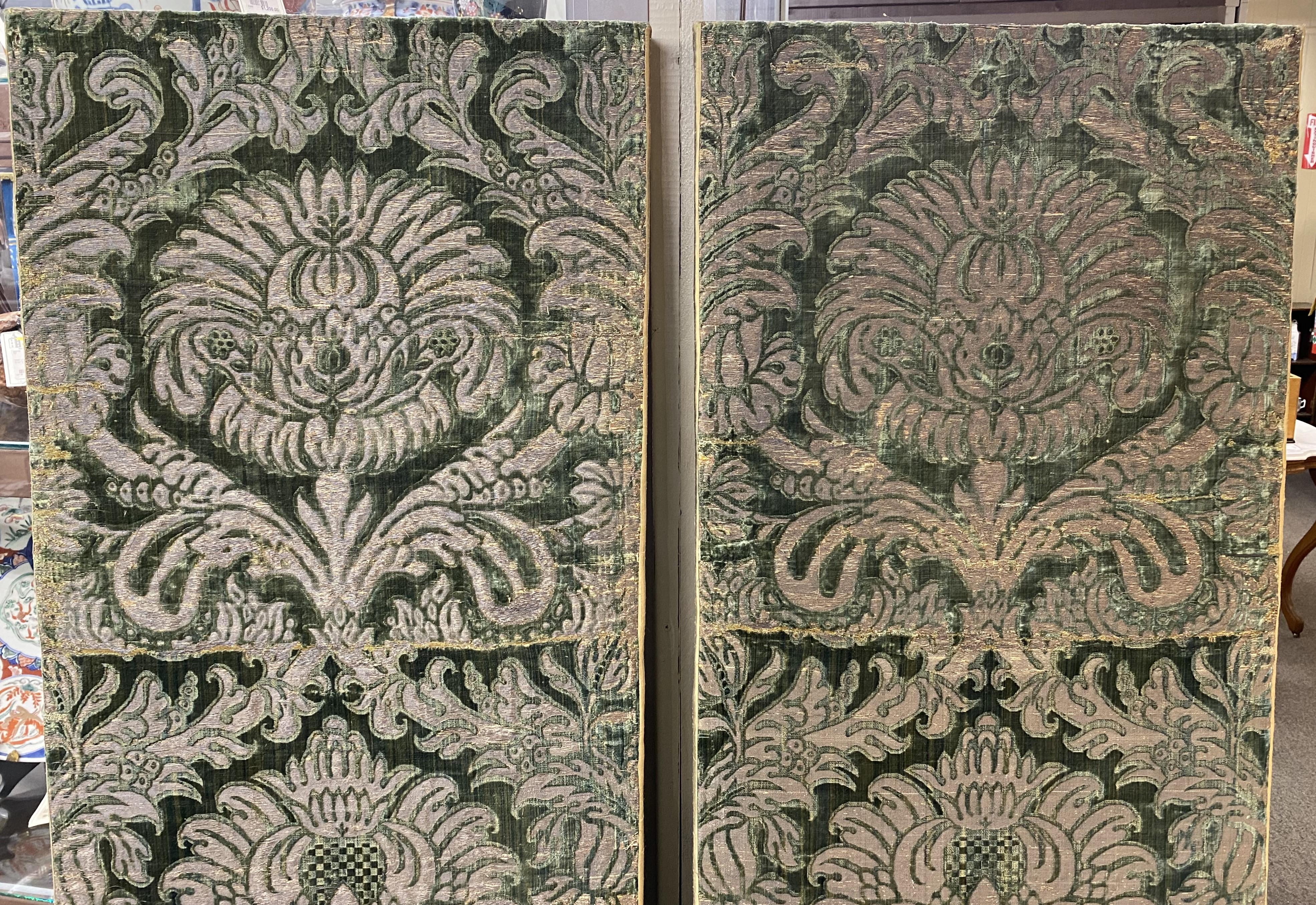 Two panels of forest green cut silk velvet with silver metal thread from Florence Italy, circa 1600-1650 with a very large floral motif rising up out of an urn. Both mounted separately on modern stretchers and edged with modern silk fabric. Fabrics