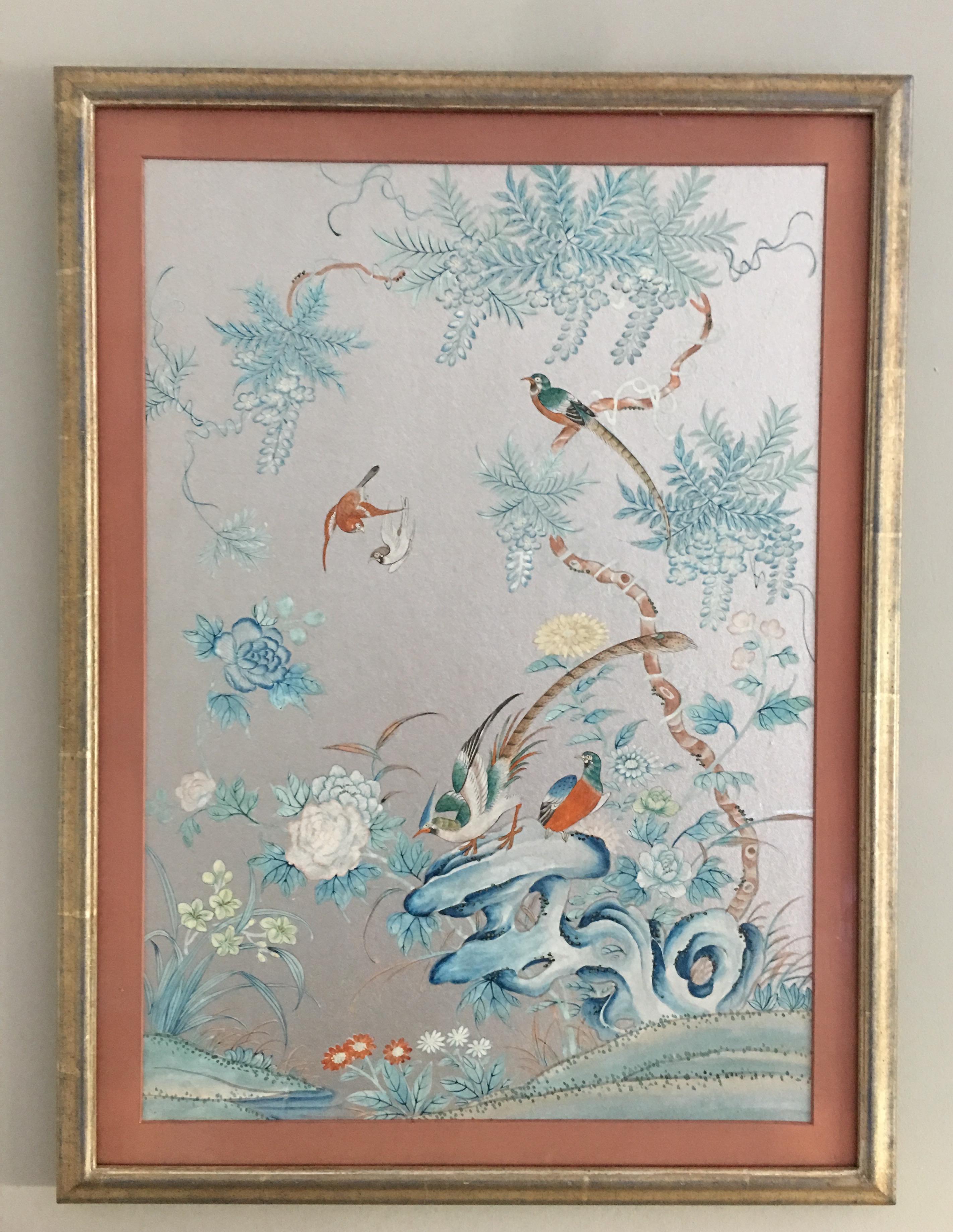 Pair of 1930s silver chinoiserie wallpaper remnant with hand-painted scenes of birds and trees. Newly custom framed in silver leaf frame with low glare glass. Each piece retains the original hand-painted salmon pink matting.