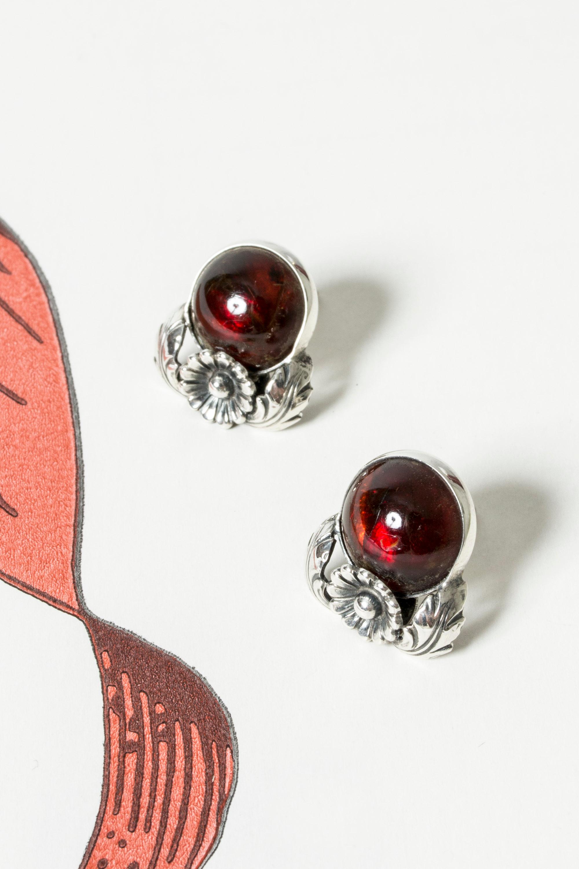 Paire de magnifiques boucles d'oreilles en argent de Niels Erik From, dans un élégant design floral aux allures d'art nouveau. Pierres ambrées rondes, taillées en cabochon, d'un rouge profond et d'un éclat chaleureux.