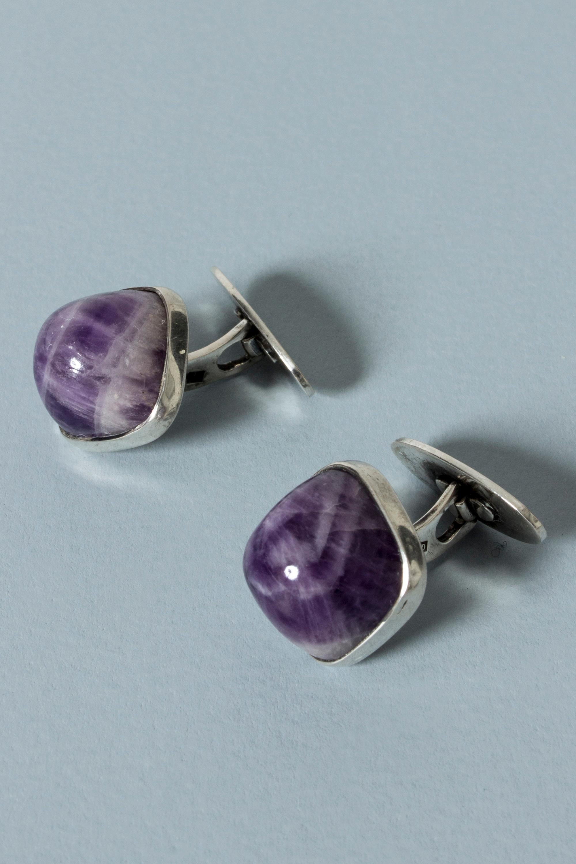 Pair of cool silver and amethyst cufflinks from Kaplans, with large, rounded, protruding stones. Layers of white in the stones.
