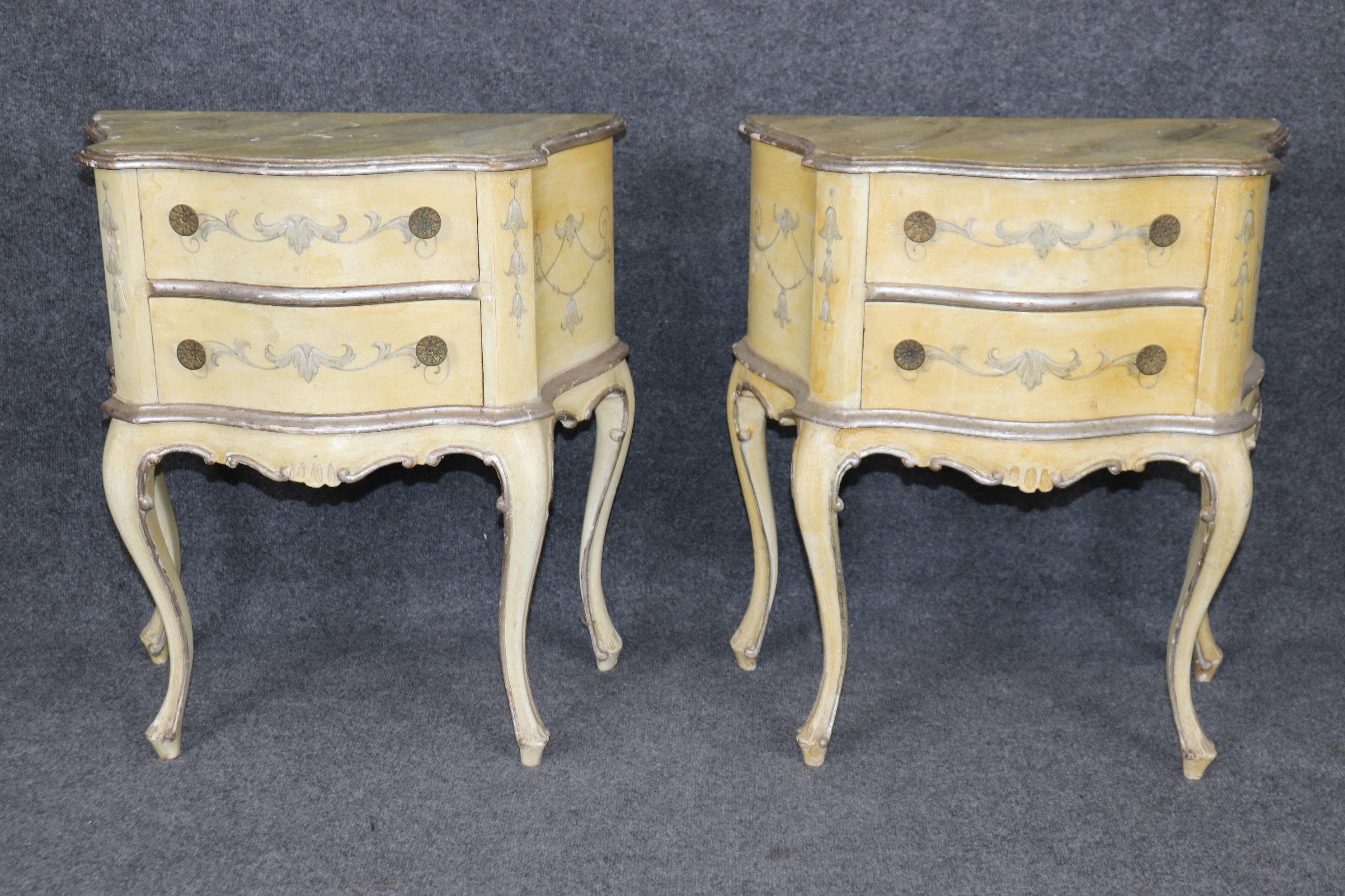 Se trata de un fantástico par de preciosas mesillas de noche de estilo Luis XV francés de Venecia, pintadas en color crema y con pan de plata. Están desgastadas por el tiempo y tienen unas magníficas encimeras de mármol de imitación decoradas a mano