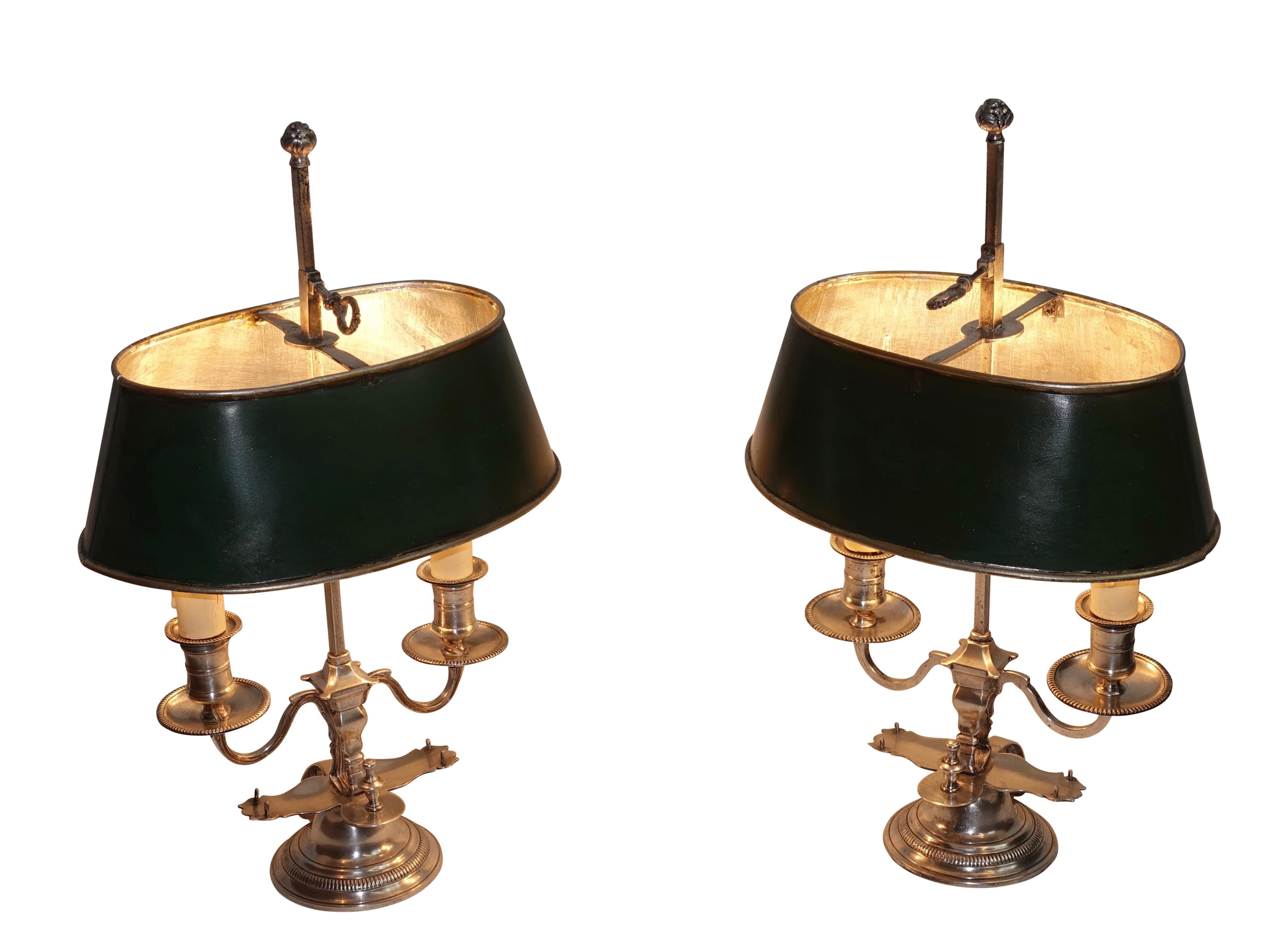 A pair of Regence period silver two-light bouillotte lamps with original oval shape tole painted shades. Recently re-wired. France, mid-18th century.
The shades were reconditioned about 50 years ago.
Lamps are lacking their candle snuffers.