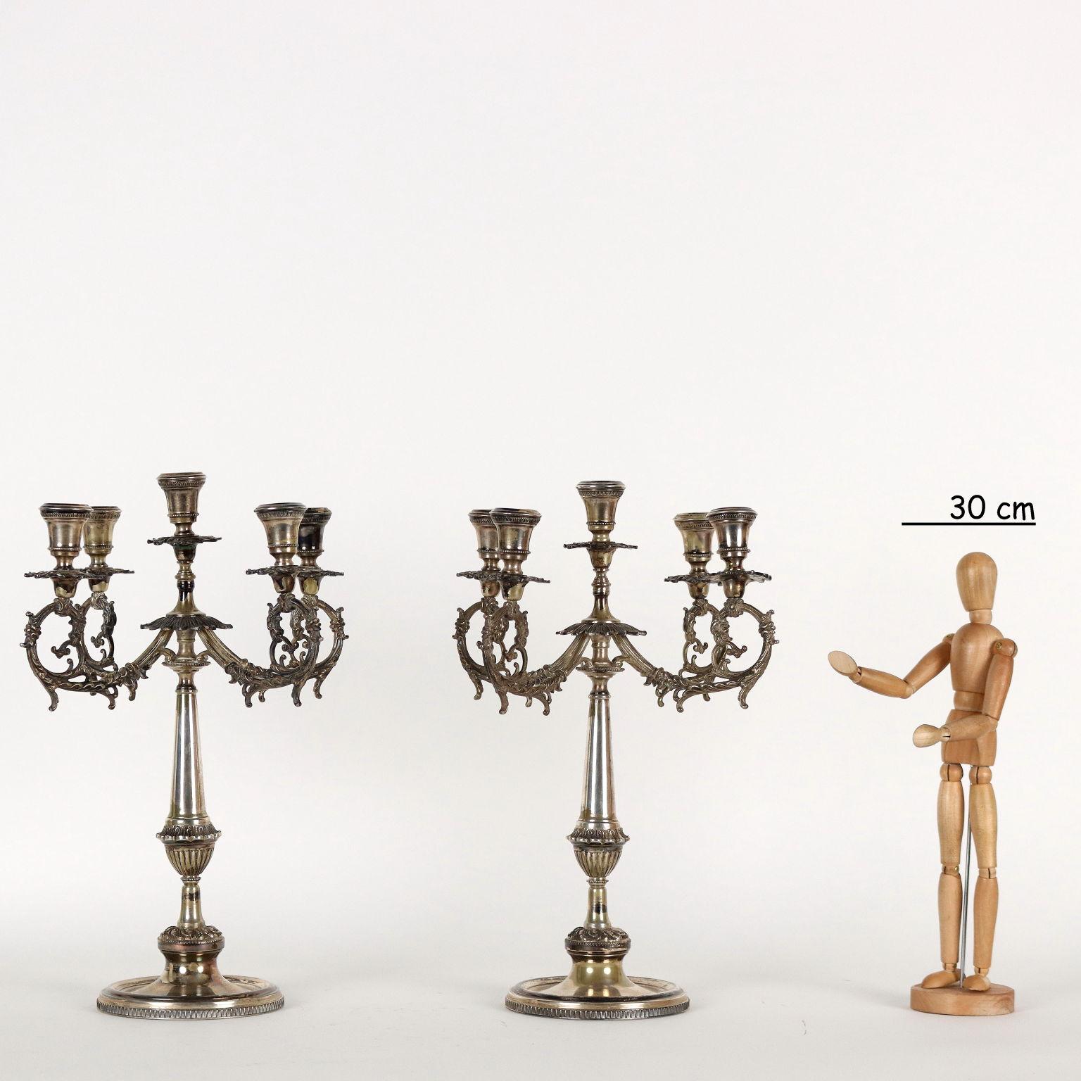Pair of five-flame silver candelabra with leaf volute arms, zoomorphic heads and plant motifs decorations. Brand of silver and silversmith engraved at the base. Grams 2830.