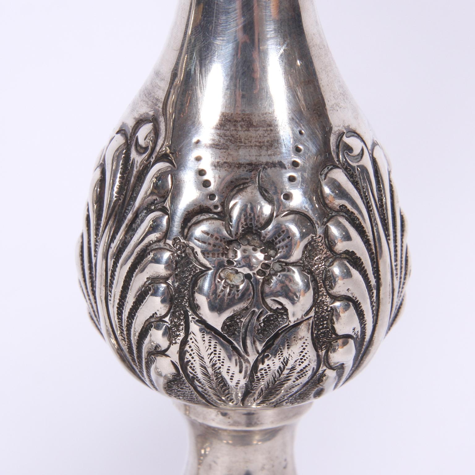 English, early 20th century.

Pair of beautiful silver candlesticks with floral design.