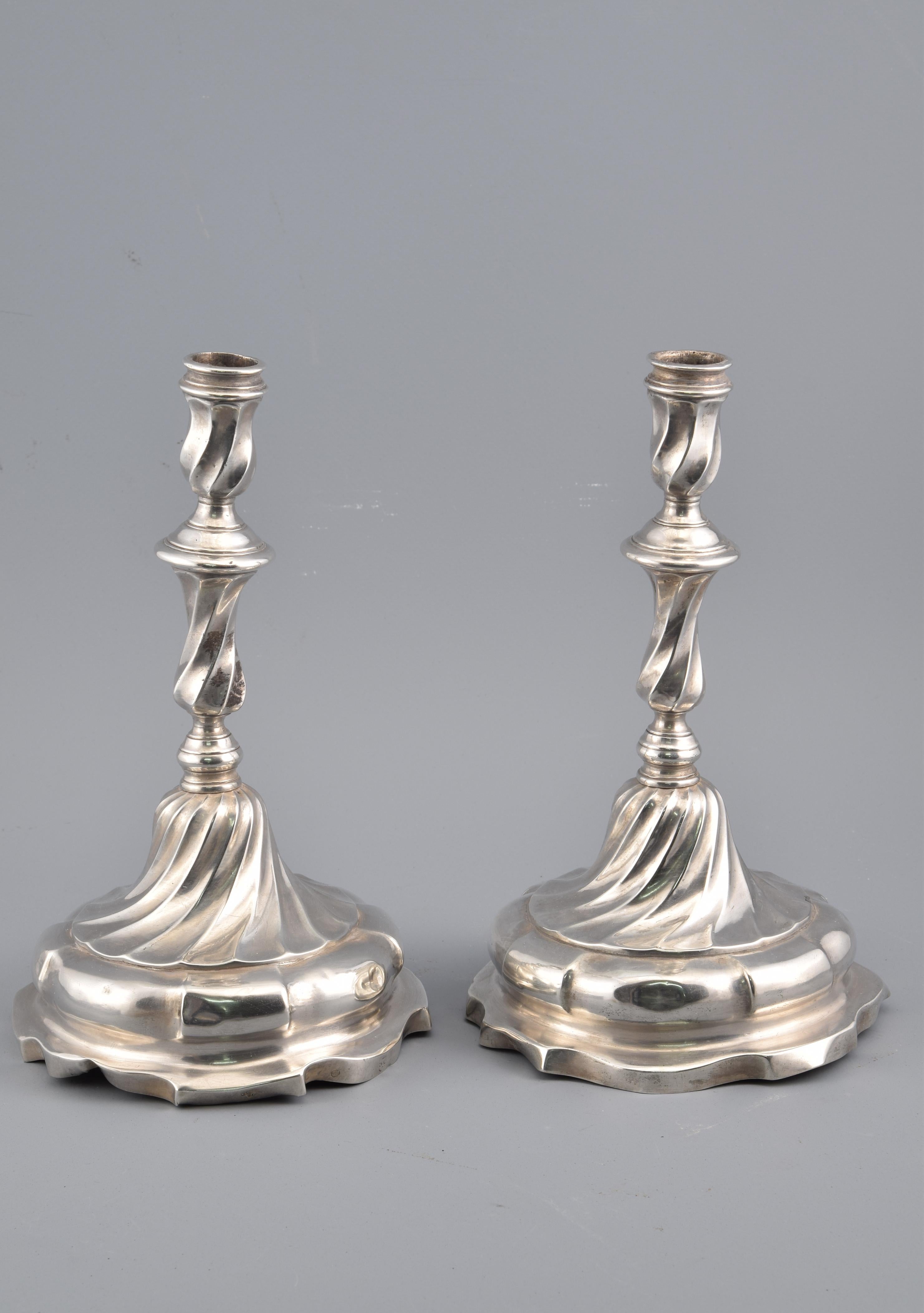 Pair of candlesticks. Silver. Possibly González Téllez, Antonio; Valladolid 1777.
With contrasting and engraved marks, and engraved shield and legend.
Pair of silver candlesticks in their color with a circular base of edges combining curves and