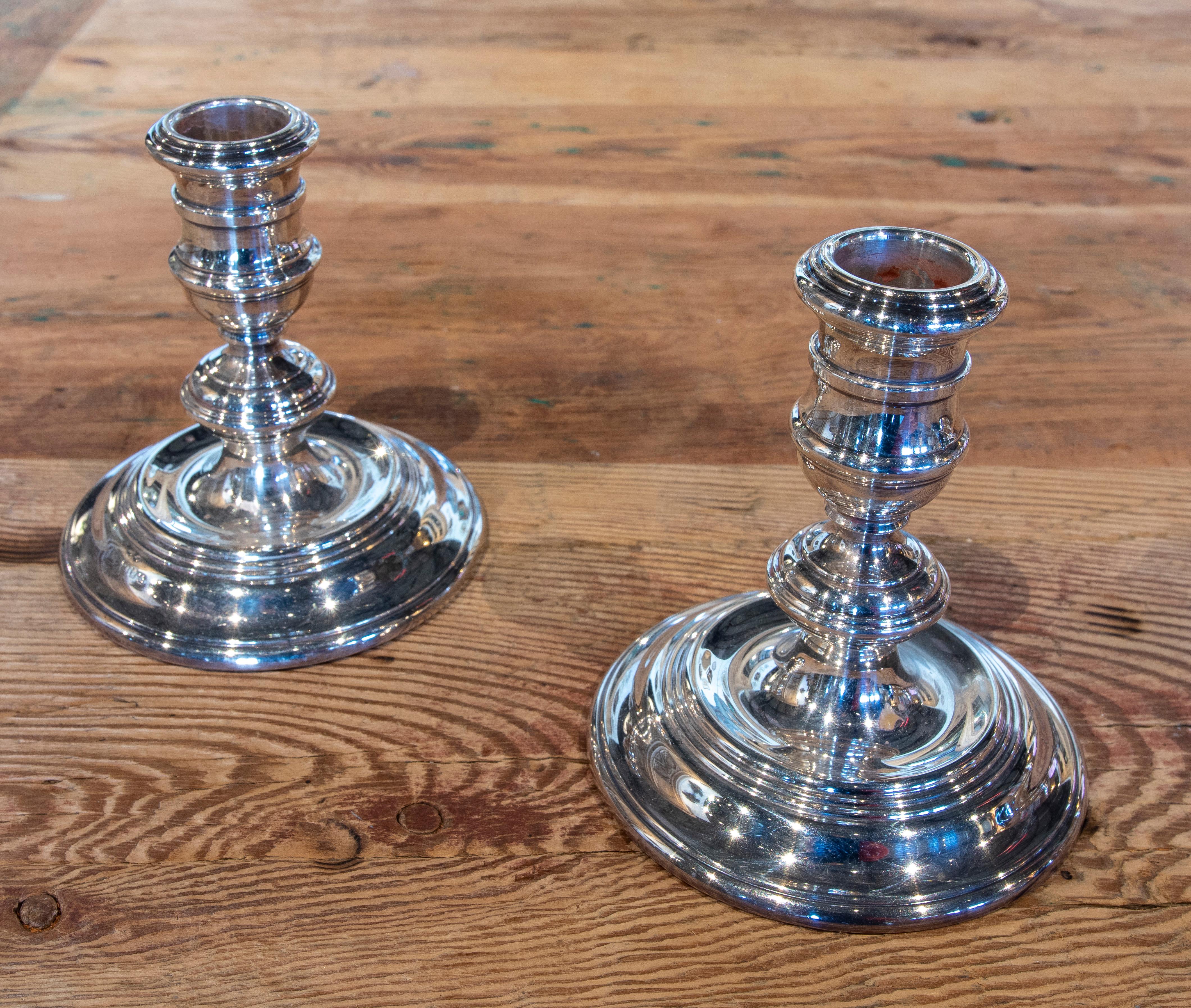 Pair of silver candlesticks with their stamps on the underside.
