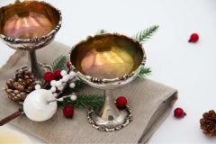 Pair of silver champagne glasses with raised rims and bases and gold interior