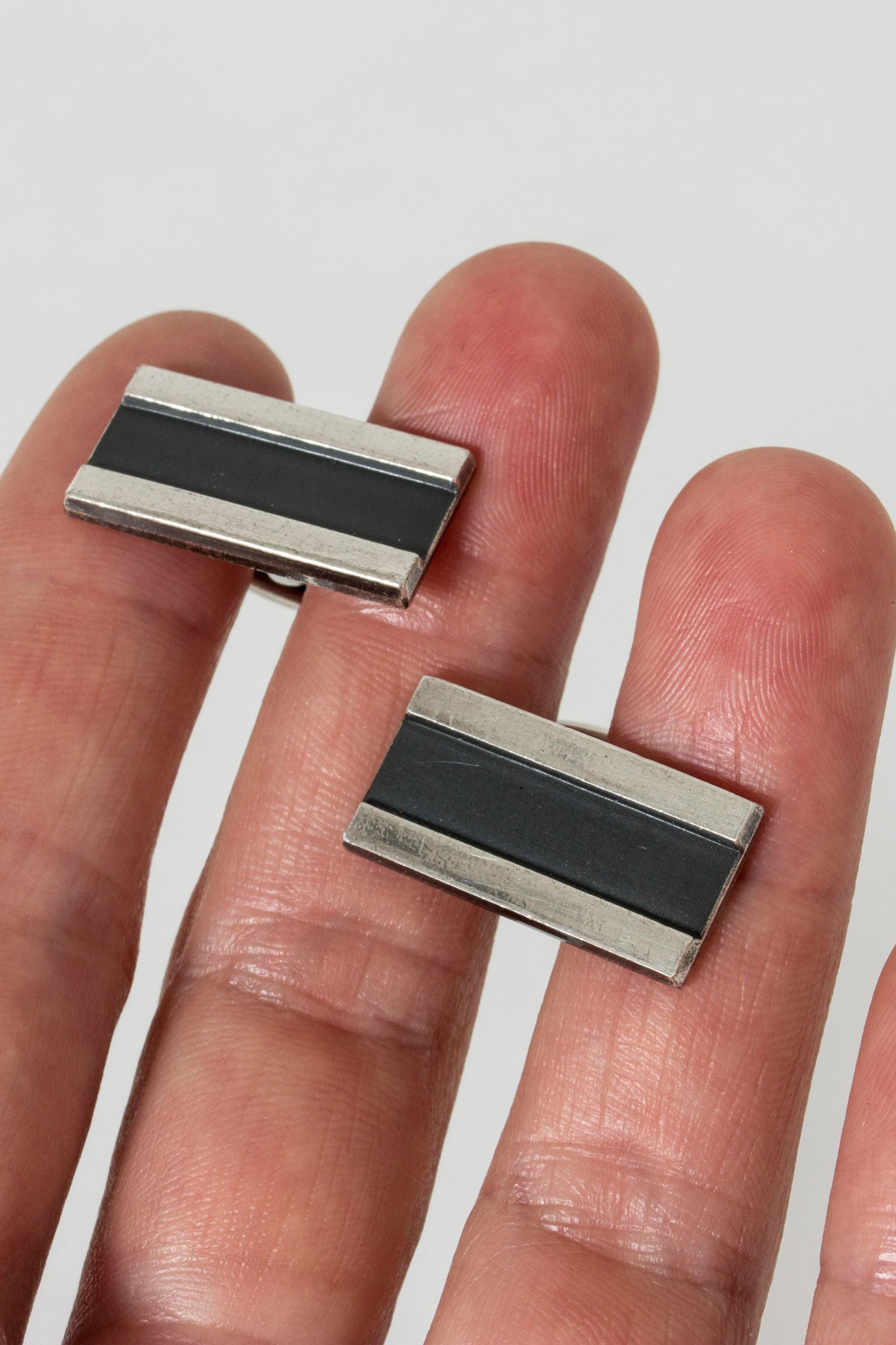 Pair of cool and elegant silver cufflinks from Sporrong with a black enamel stripe through the middle.
