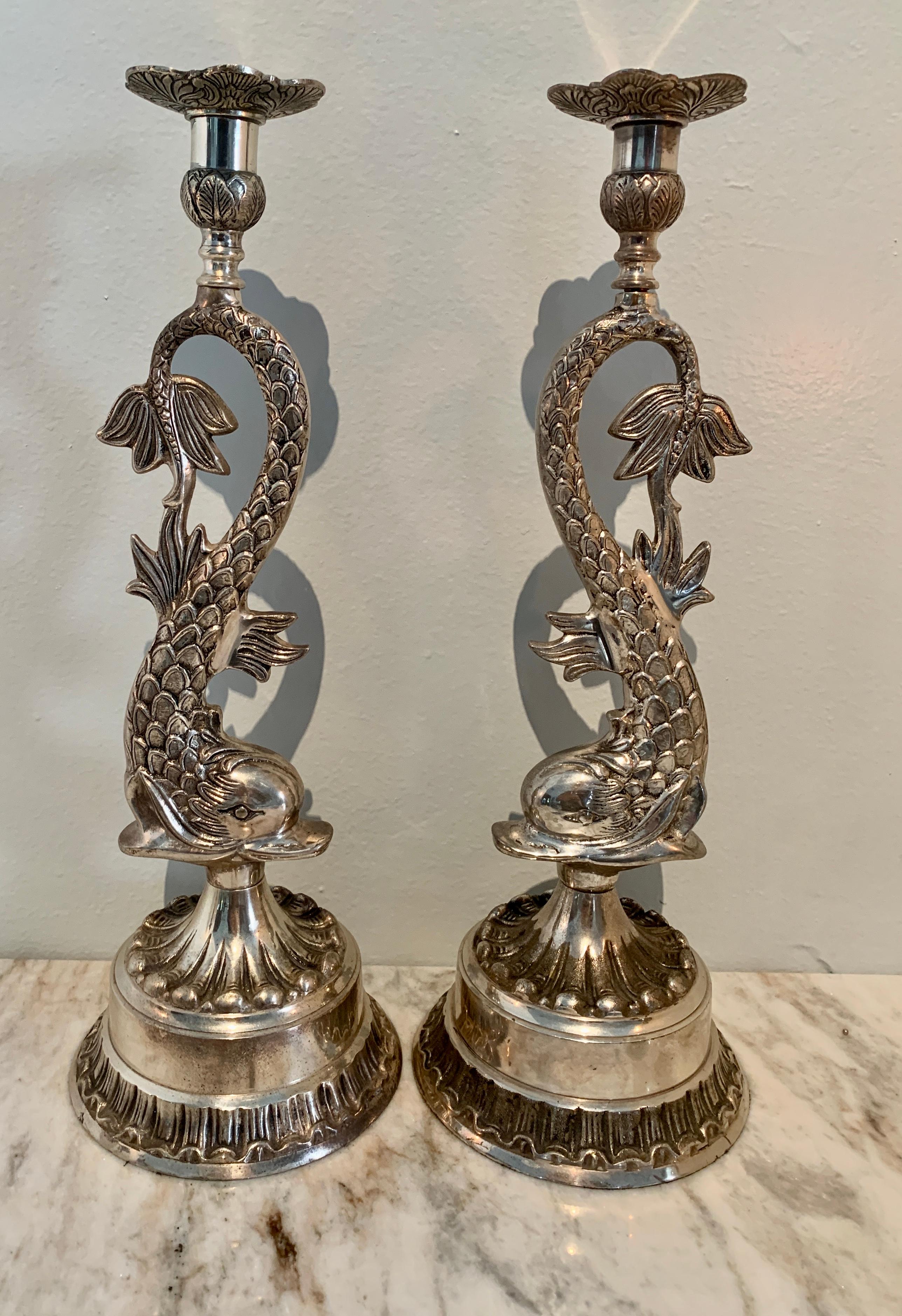 Pair of tall and impressive dolphin candlesticks. The pair are perfectly suited for the dining table or atop a mantle.