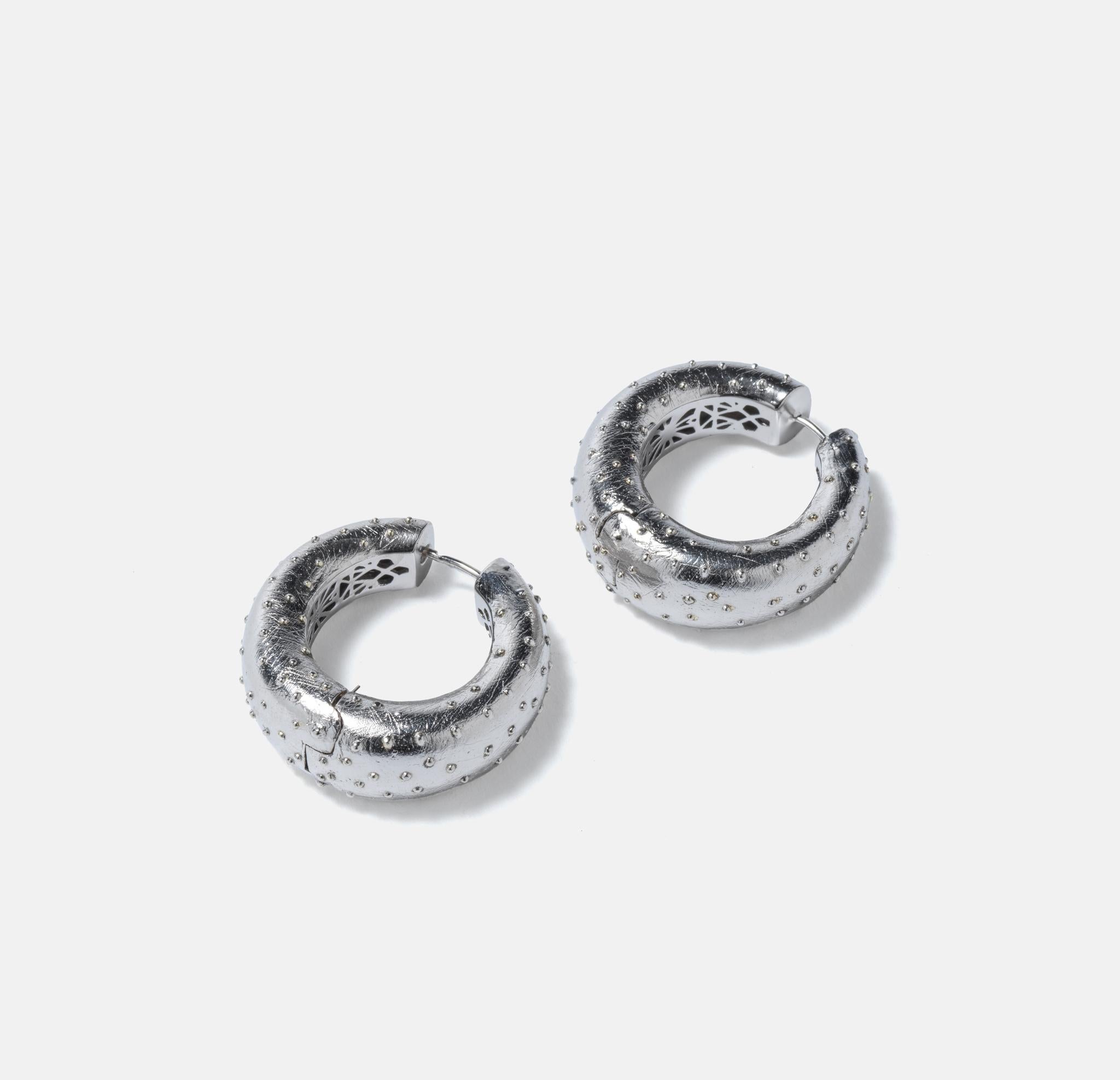 These ear rings called Osiris designed by Swedish designer and silversmith Paula Pantolin are made of silver with a design that is meant look like ostrich skin. They are quite large in size and have heavy feeling to them. They look like RocknRoll.

