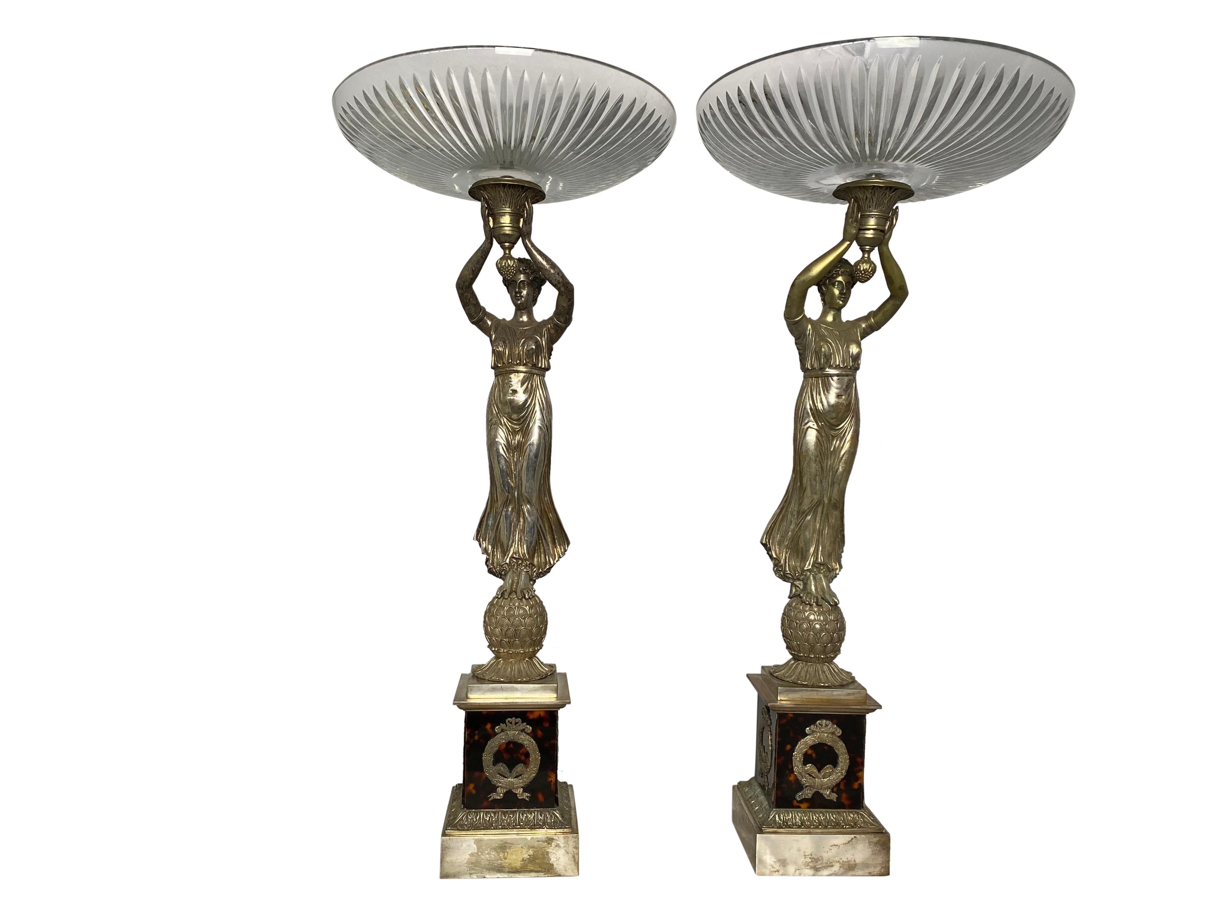 This fine pair of French, silver, allegorical tazzas are tortoiseshelled. They include detailed wreaths on the walls of the base. A finely dressed woman holds each dish proudly above her head. Very unique in style, this pair make exceptional