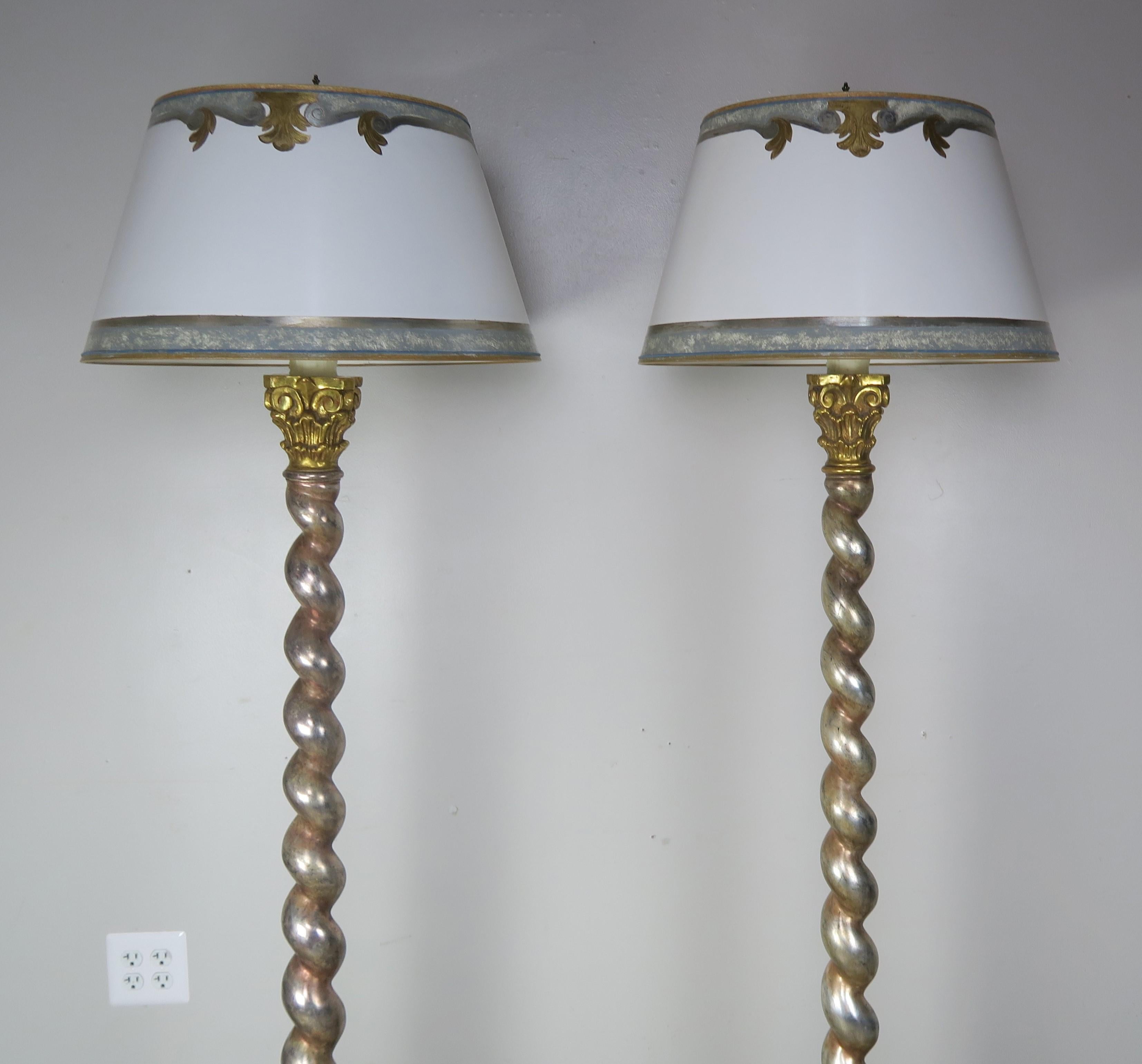 Pair of Italian twisted barley silver and gold leaf gilt standing lamps newly re-wired and crowned with hand painted parchment shades. The lamps are newly rewired with drip wax candles. Ready to install.