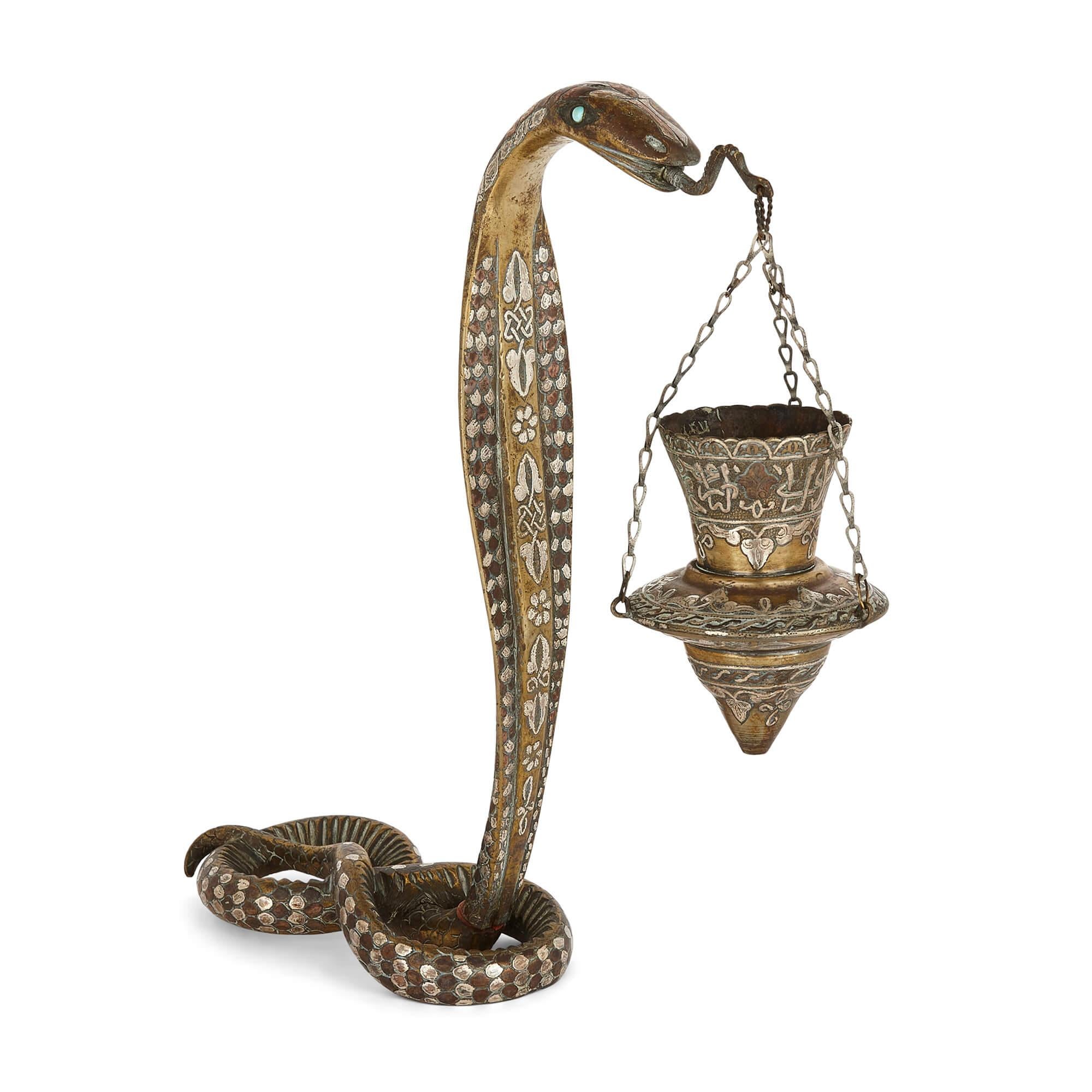 Pair of silver-inlaid brass Art Deco serpent candle holders
Continental, c.1920
Height 32/34cm, width 9cm, depth 30cm

Dating to the time of the Art Deco period in the first quarter of the twentieth century, these fine lighting pieces are a pair