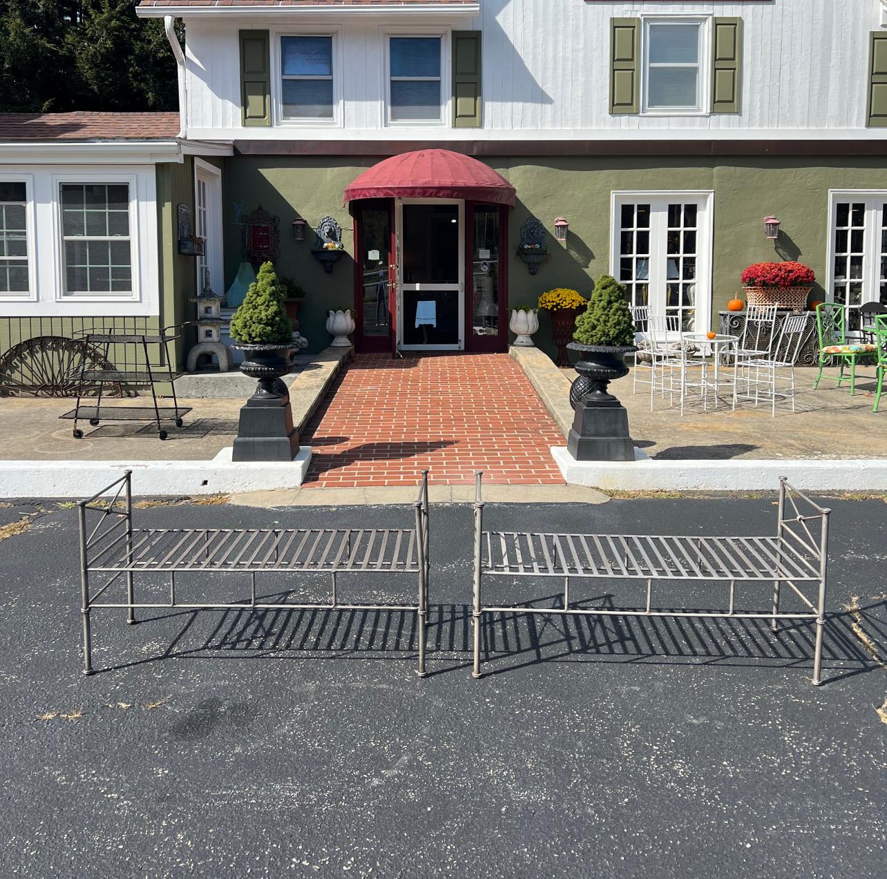 Paar silberne Eisenbänke oder Sofas. Klassisches neoklassisches modernes Design. Perfekt für einen formellen Eingangsbereich oder ein Gartenzimmer. Can auch am Fußende eines Bettes verwendet werden. Am besten für den Innenbereich geeignet, nicht für