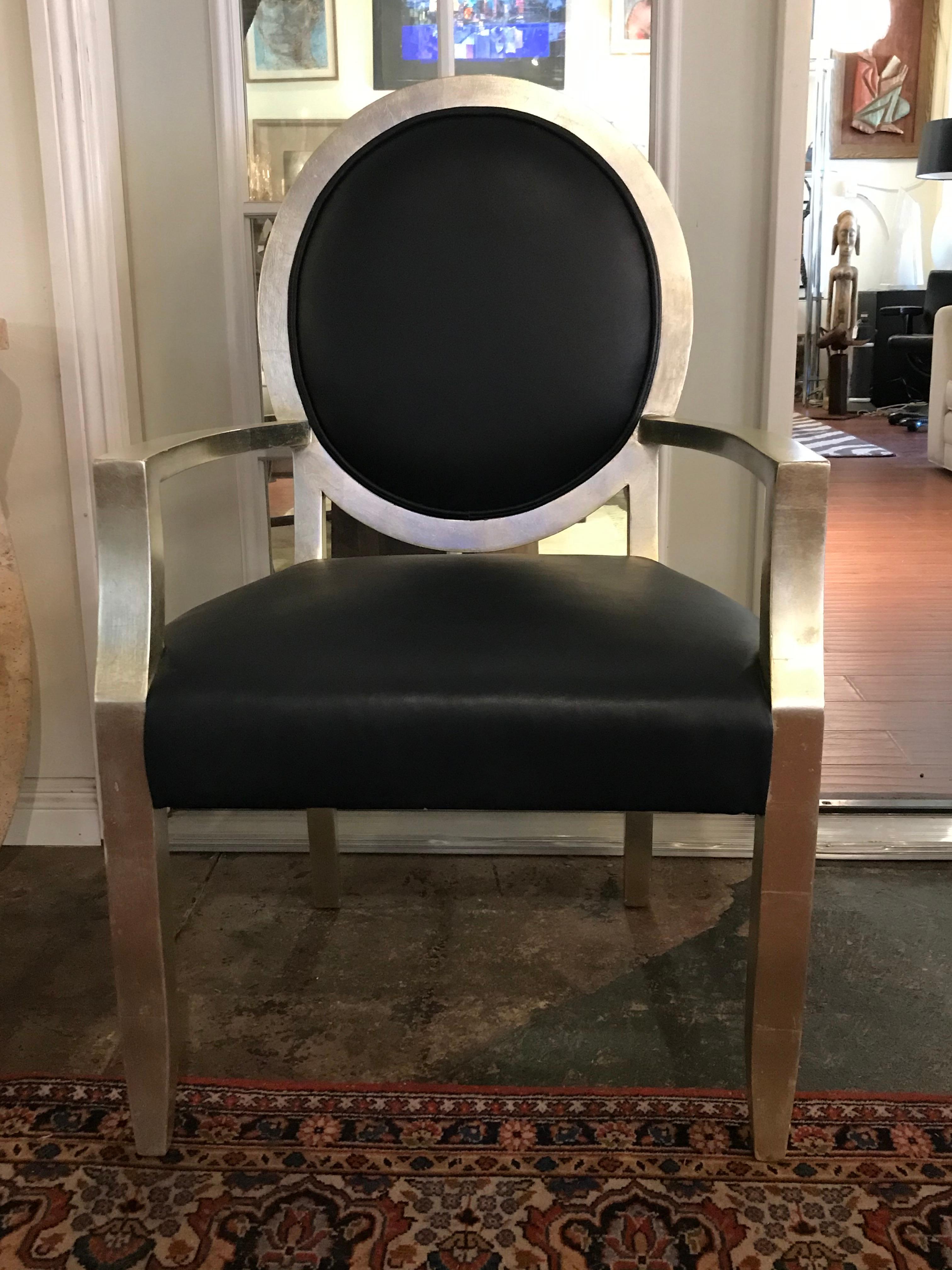 Inspired by the Louis XVI style, these chairs' wood features a silver leaf finish and are recovered in dark blue leather (look almost black)