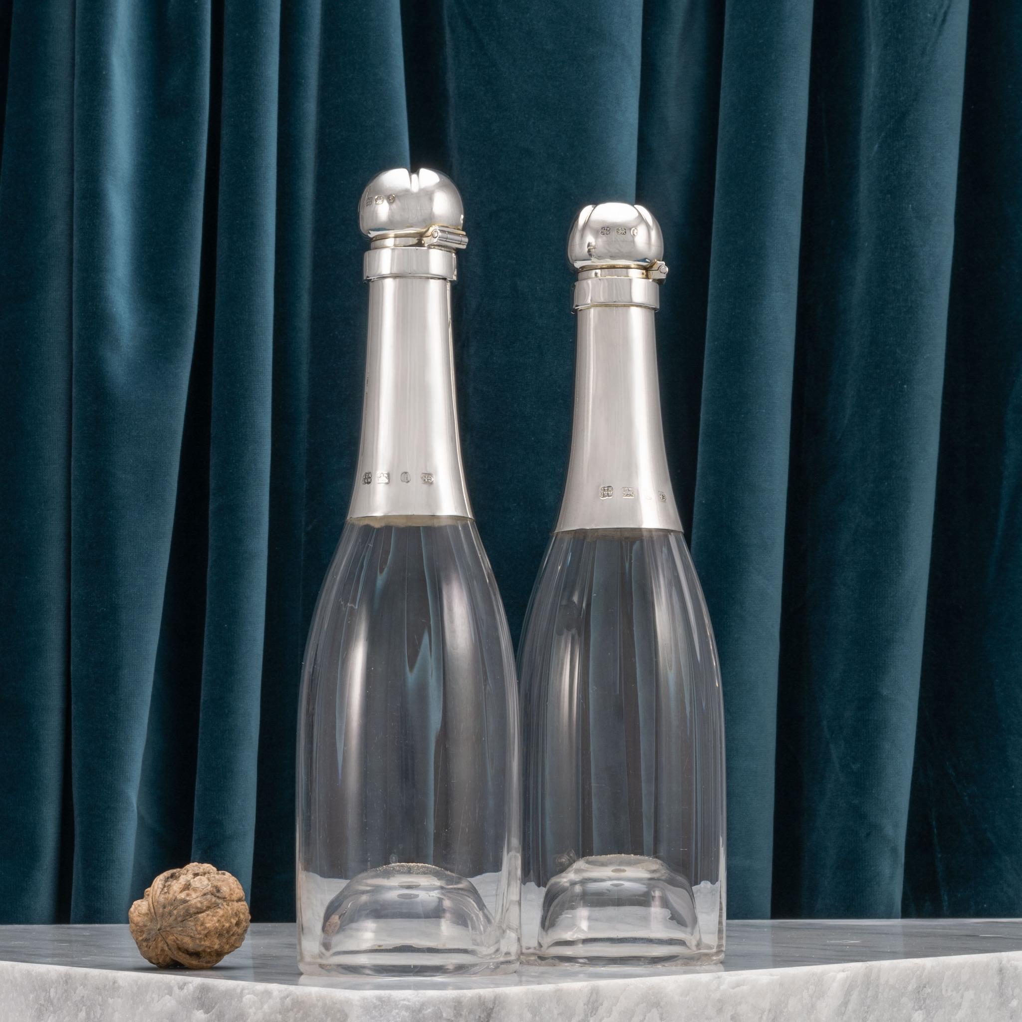 Splendidi decanter per bottiglie di Champagne con capacità di mezza bottiglia. Il corpo in vetro è scanalato in modo davvero elegante, solo all'interno, in modo che la superficie esterna del decanter rimanga liscia. Il collo e il tappo a cerniera in