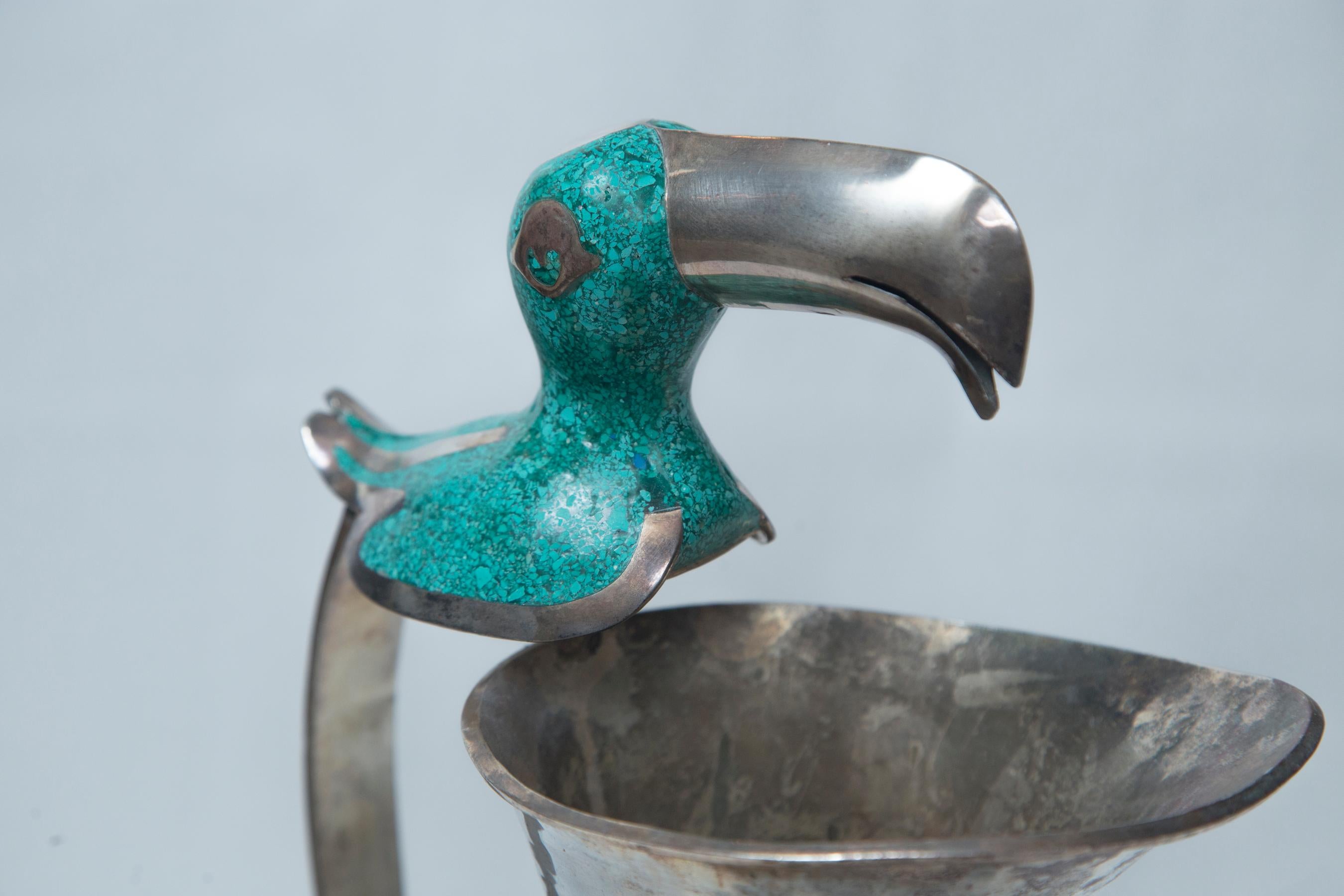 The handles inlaid with and the heads covered in turquoise.
Unsigned.
They are of different heights. The toucan being 14 inches tall with a 6 inch diameter at its widest point (approximate.) The parrot being 14.5 inches tall, with a 7 inch