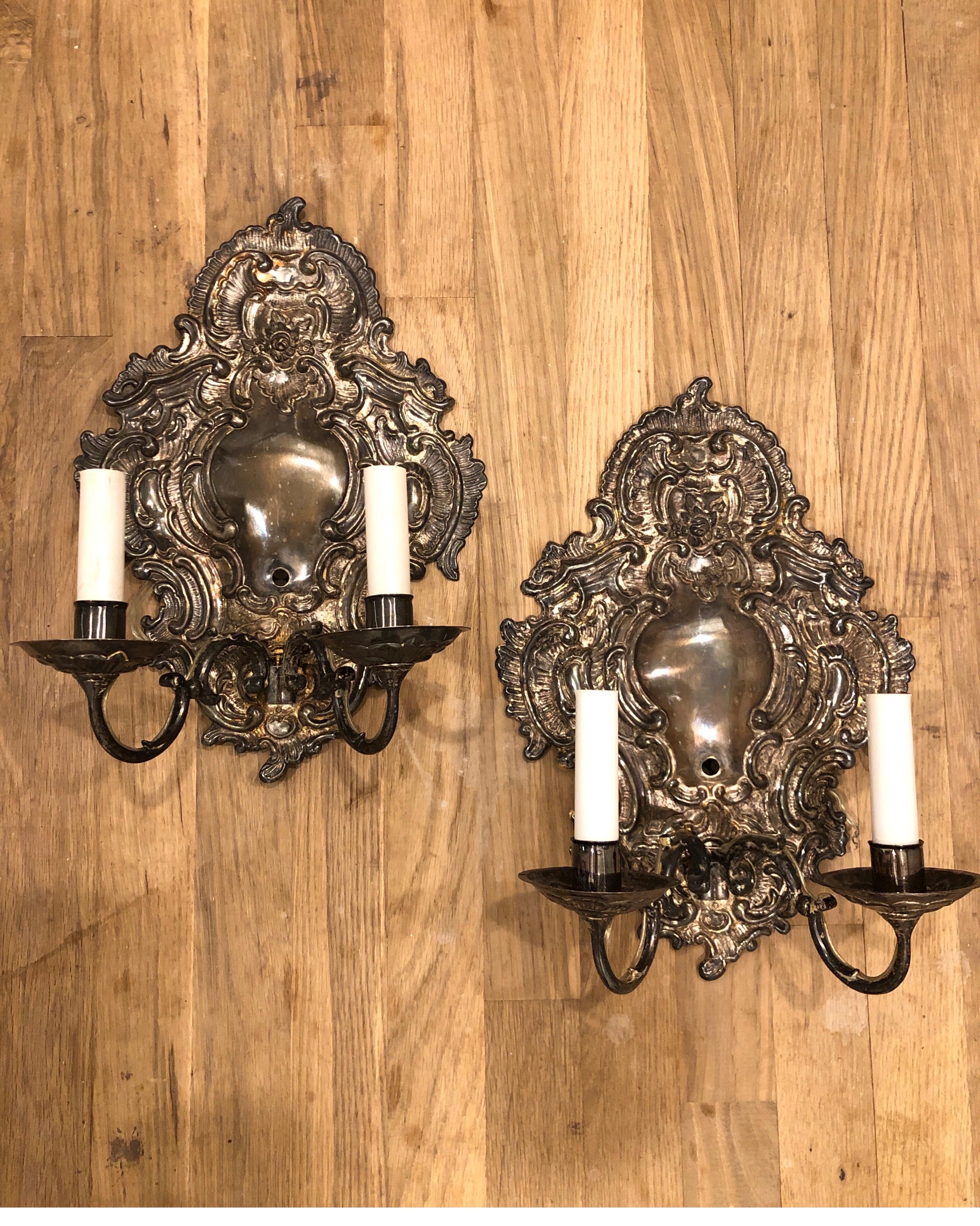 Pair of Paul Ferrante wall sconces. Silver plating with detailed relief backplates. Double S-curved arms.

Selling as a pair.