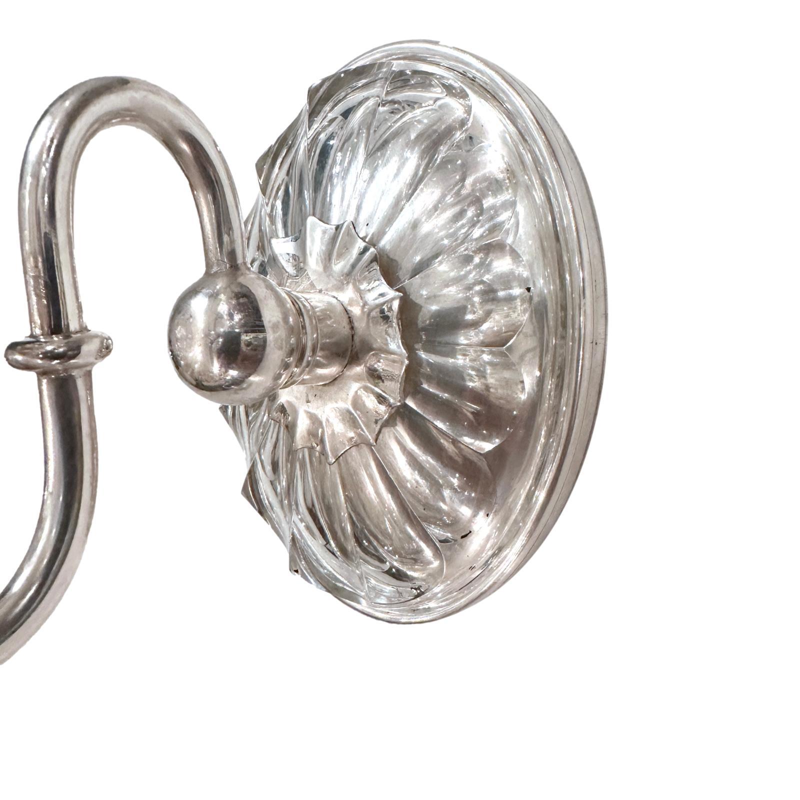 Coppia di applique a luce singola placcate in argento del 1950 circa con corpo in vetro stampato.

Misure:
Altezza: 7.5