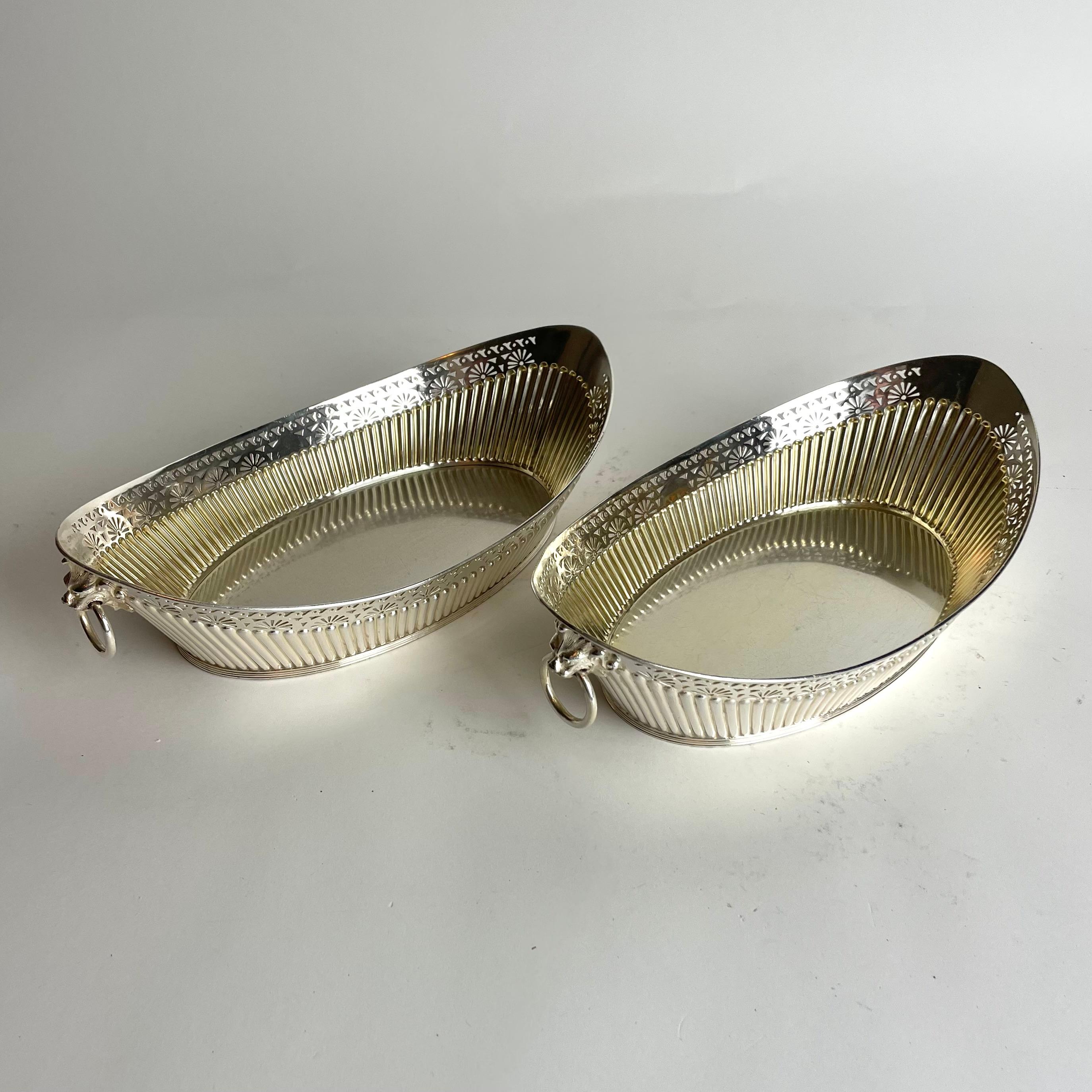 Un par de elegantes Paneras plateadas con decoración de leones de James Dixon & Sons (1835-1920) de Sheffield, Inglaterra. Fabricado durante el siglo XIX. Parcialmente dorado en el interior. Parte inferior con inscripción de regalo. (Ver